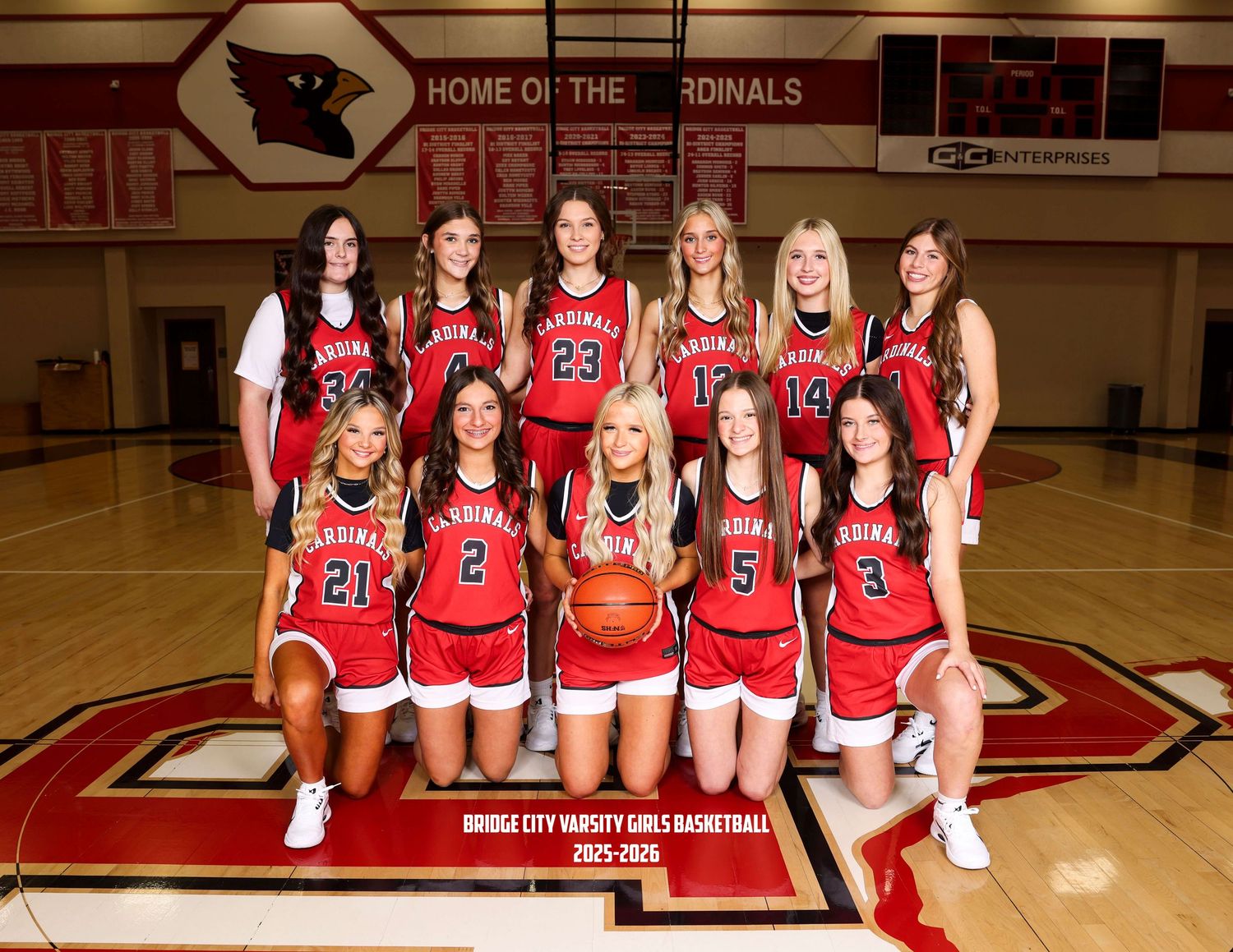High school basketball team poses for official team photo in red uniforms.