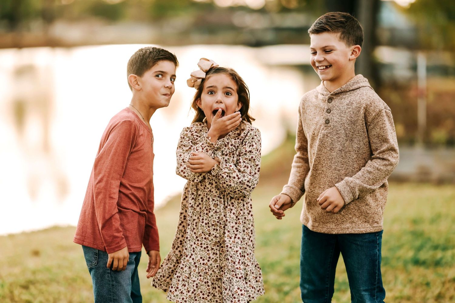 Children playing and laughing together outdoors in warm evening light.