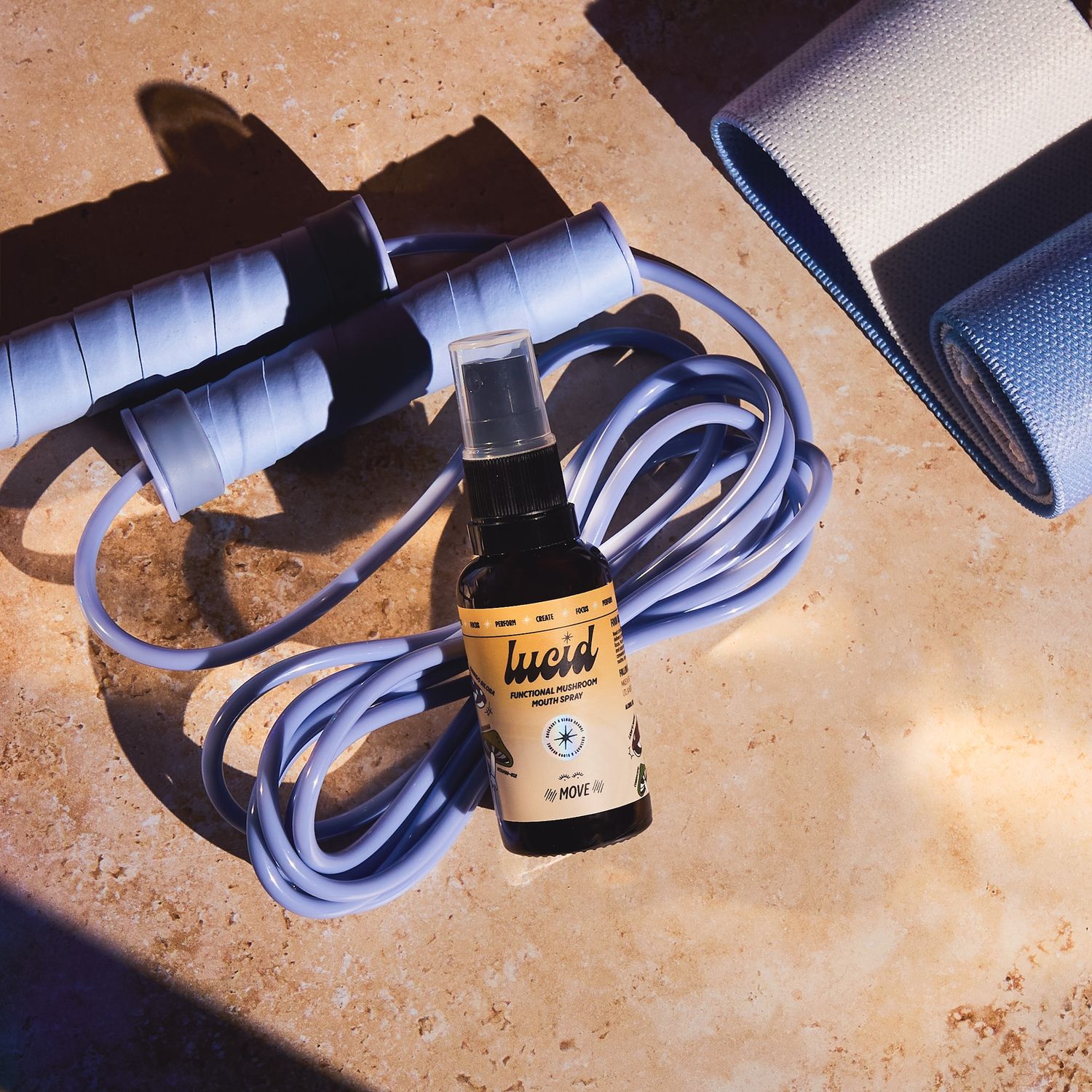 Small amber bottle with charging cable arranged on textured surface.