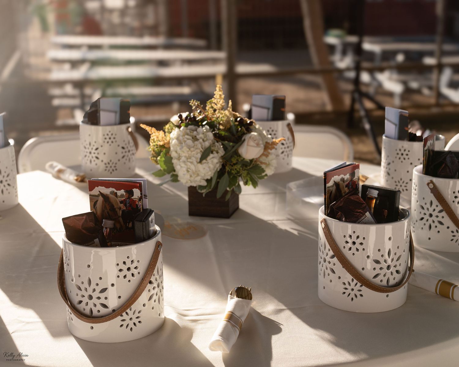 White ceramic lanterns and decorative items arranged on a table in natural sunlight.