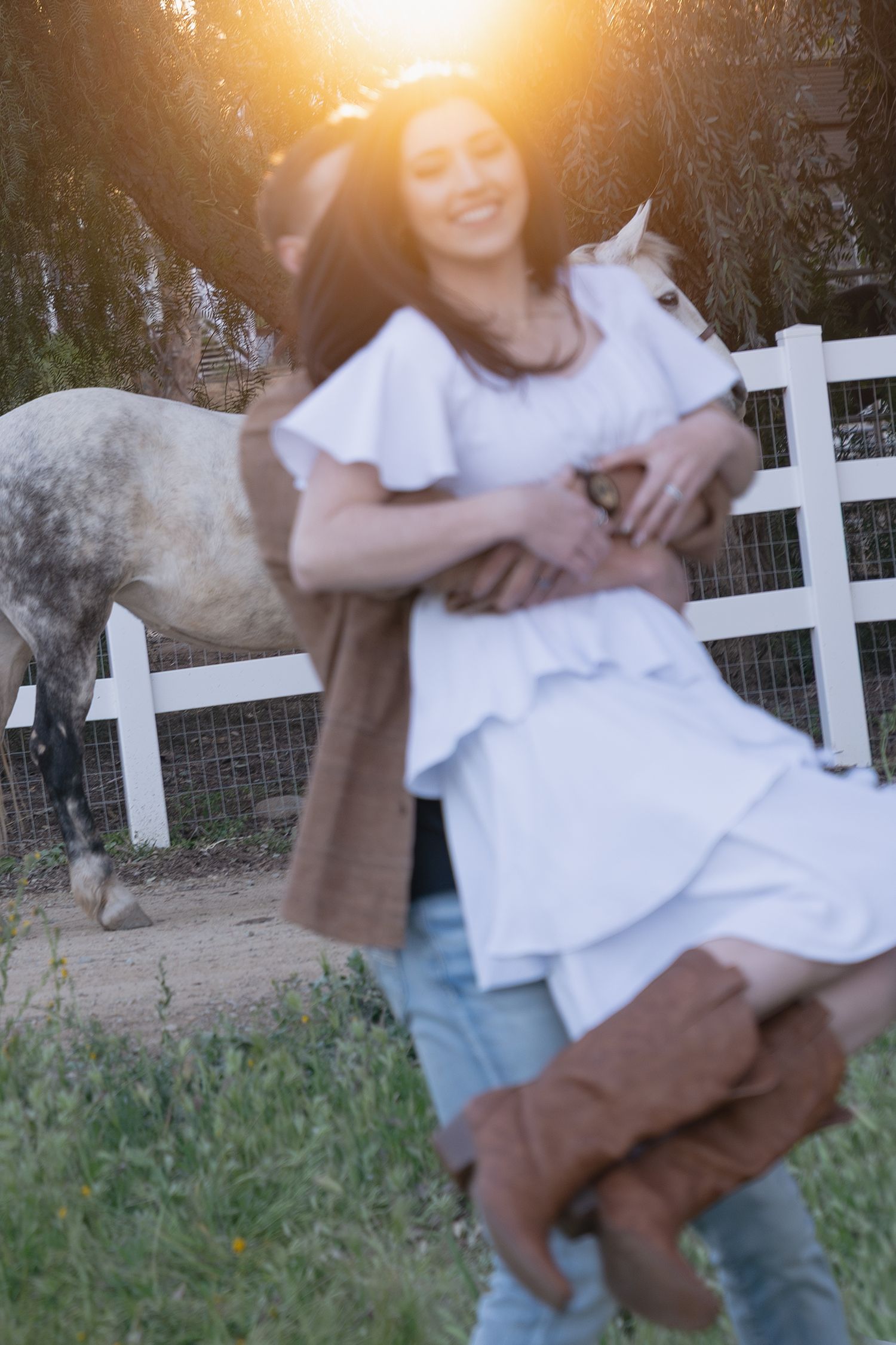 A playful sequence of someone being swung around in a white dress against a white picket fence at sunset.