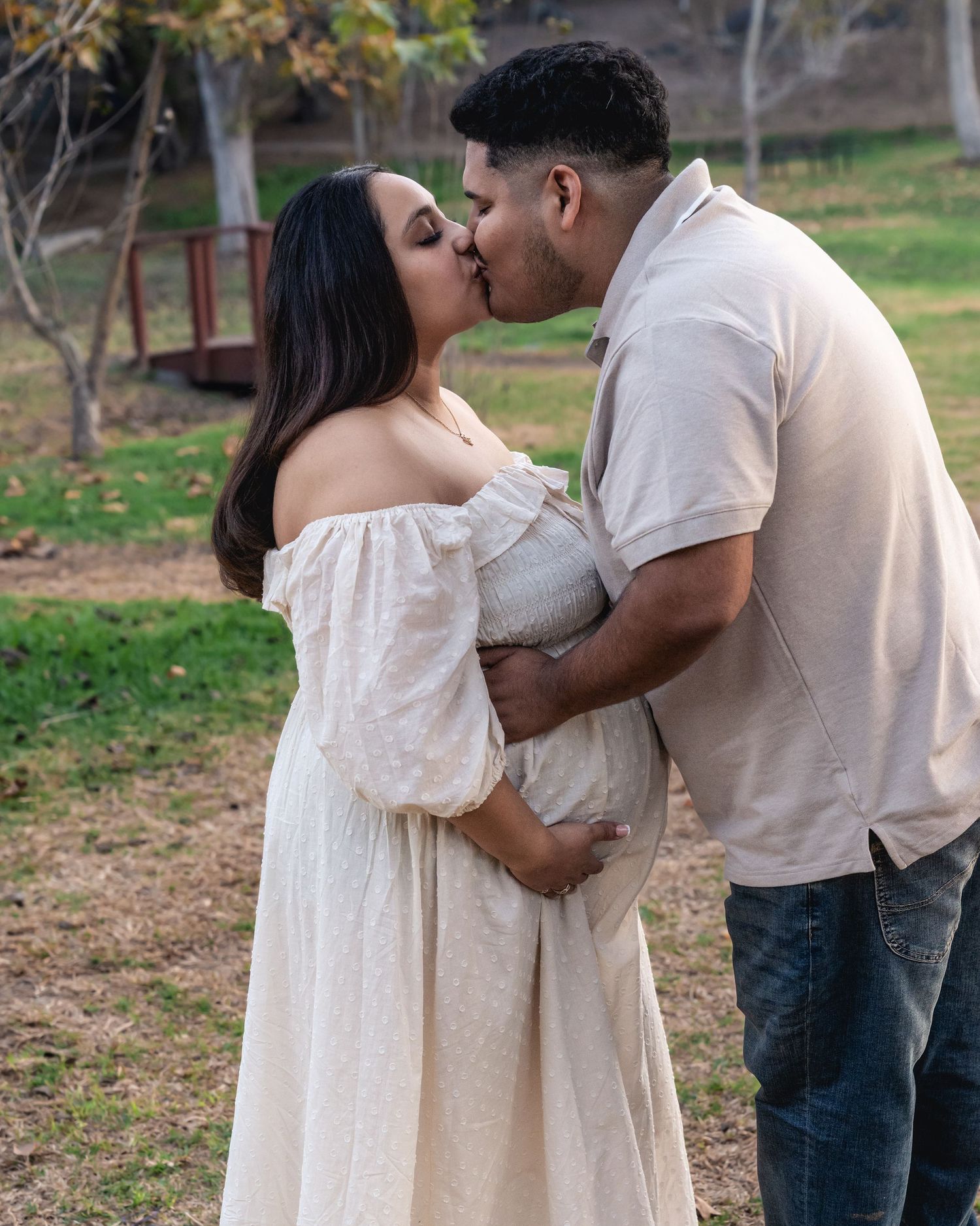 A romantic moment captured between a couple in a park setting.