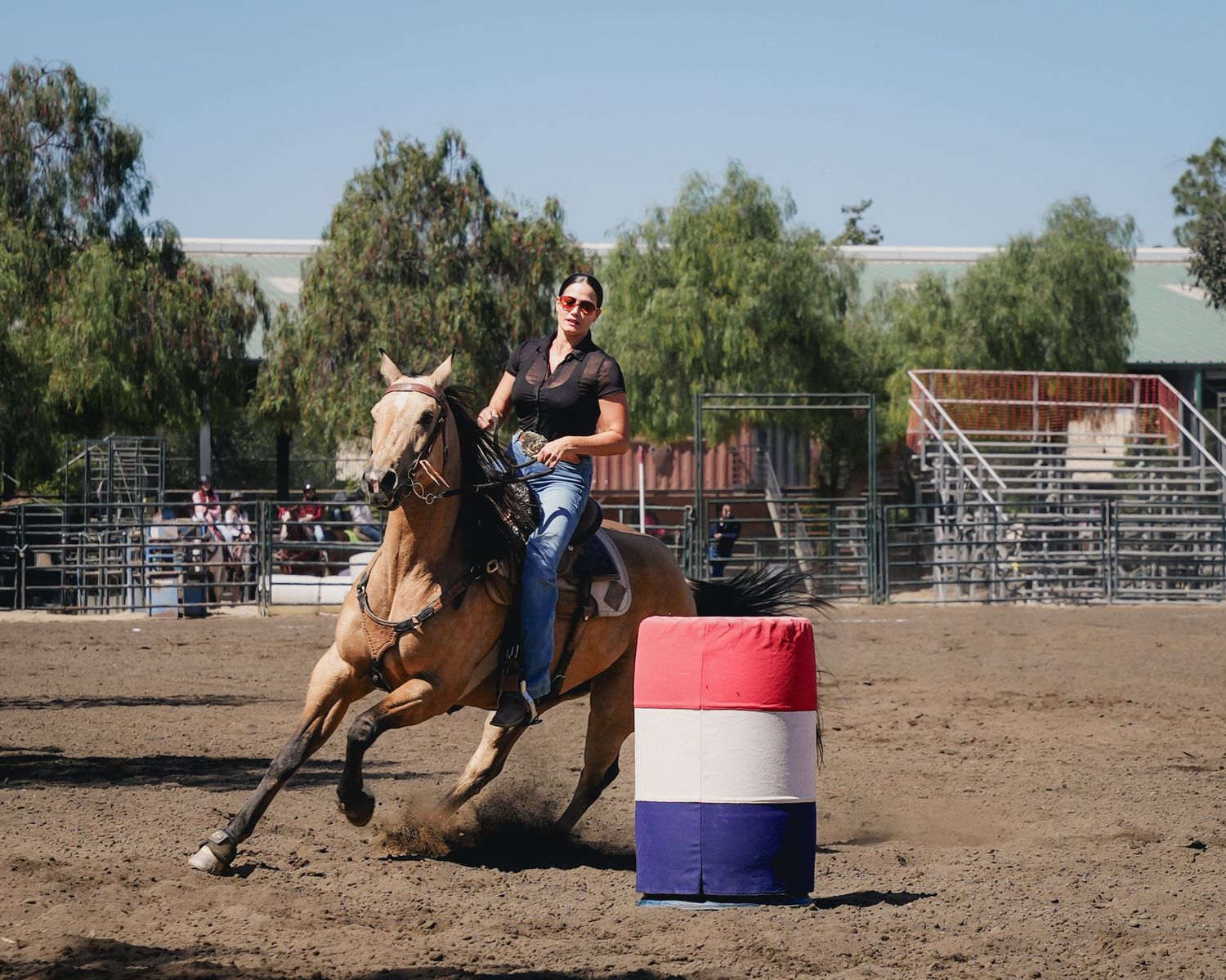 Horse and rider demonstrate speed and agility during barrel racing competition.