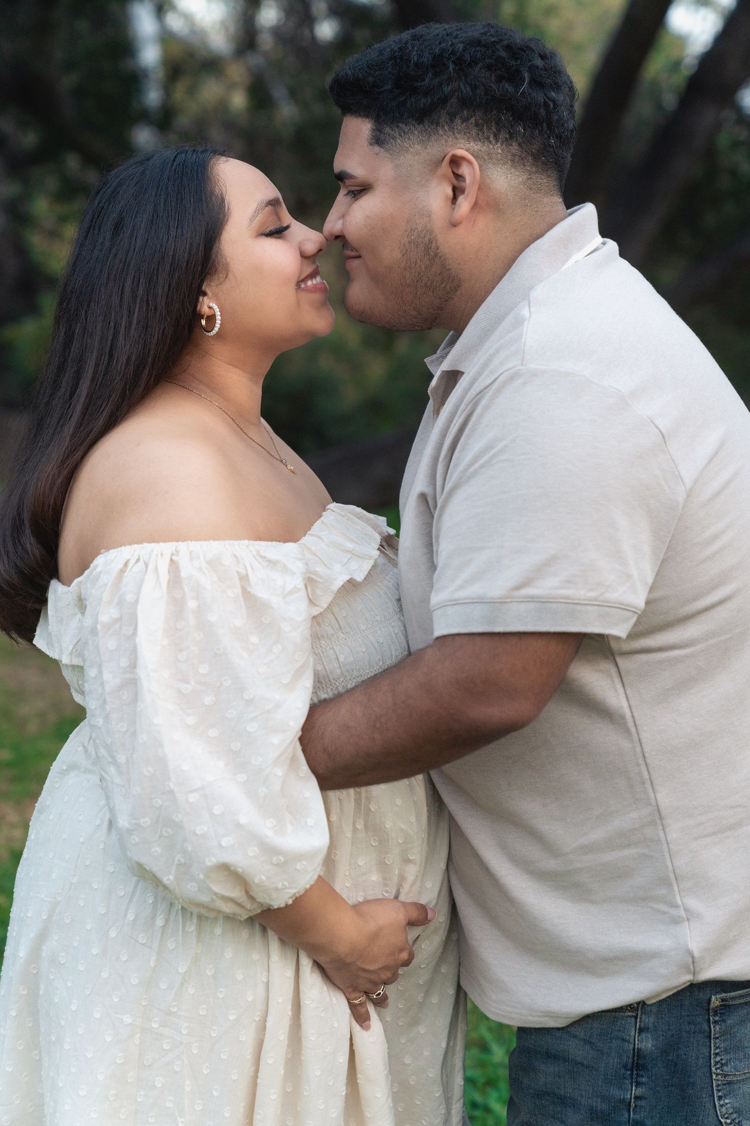 An intimate portrait of a couple sharing a tender moment outdoors.