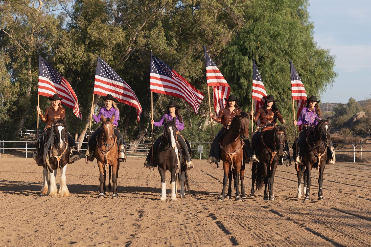 Equestrian team lines up with American flags for ceremonial display.