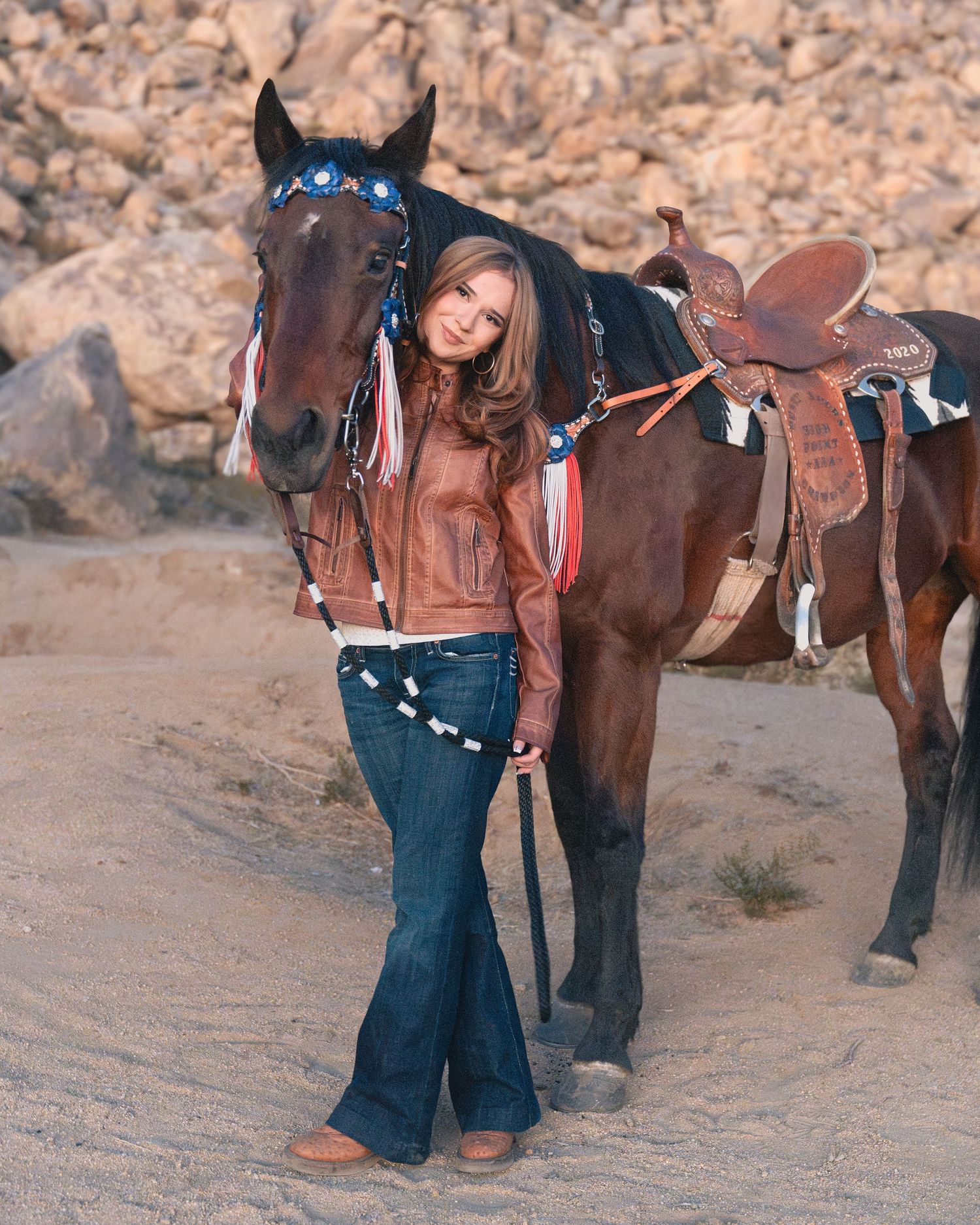 Western tack and saddle details on brown horse in desert setting.