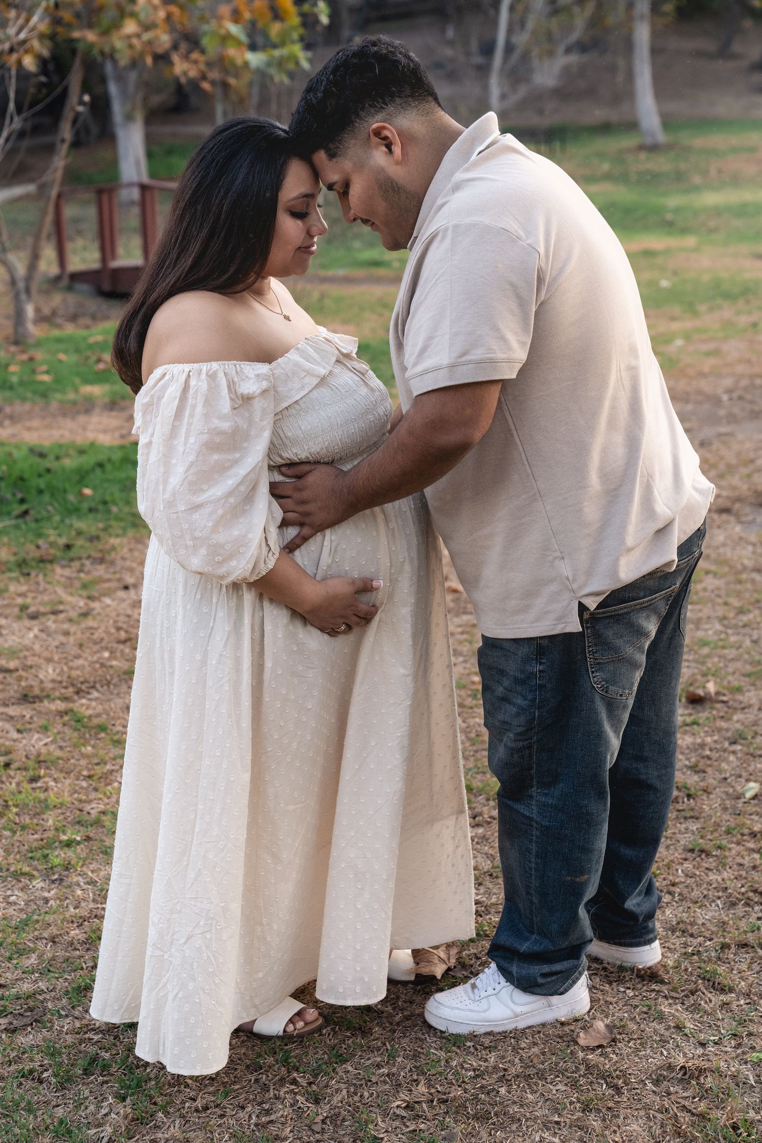 A couple shares an intimate moment during their outdoor photoshoot in coordinated outfits.
