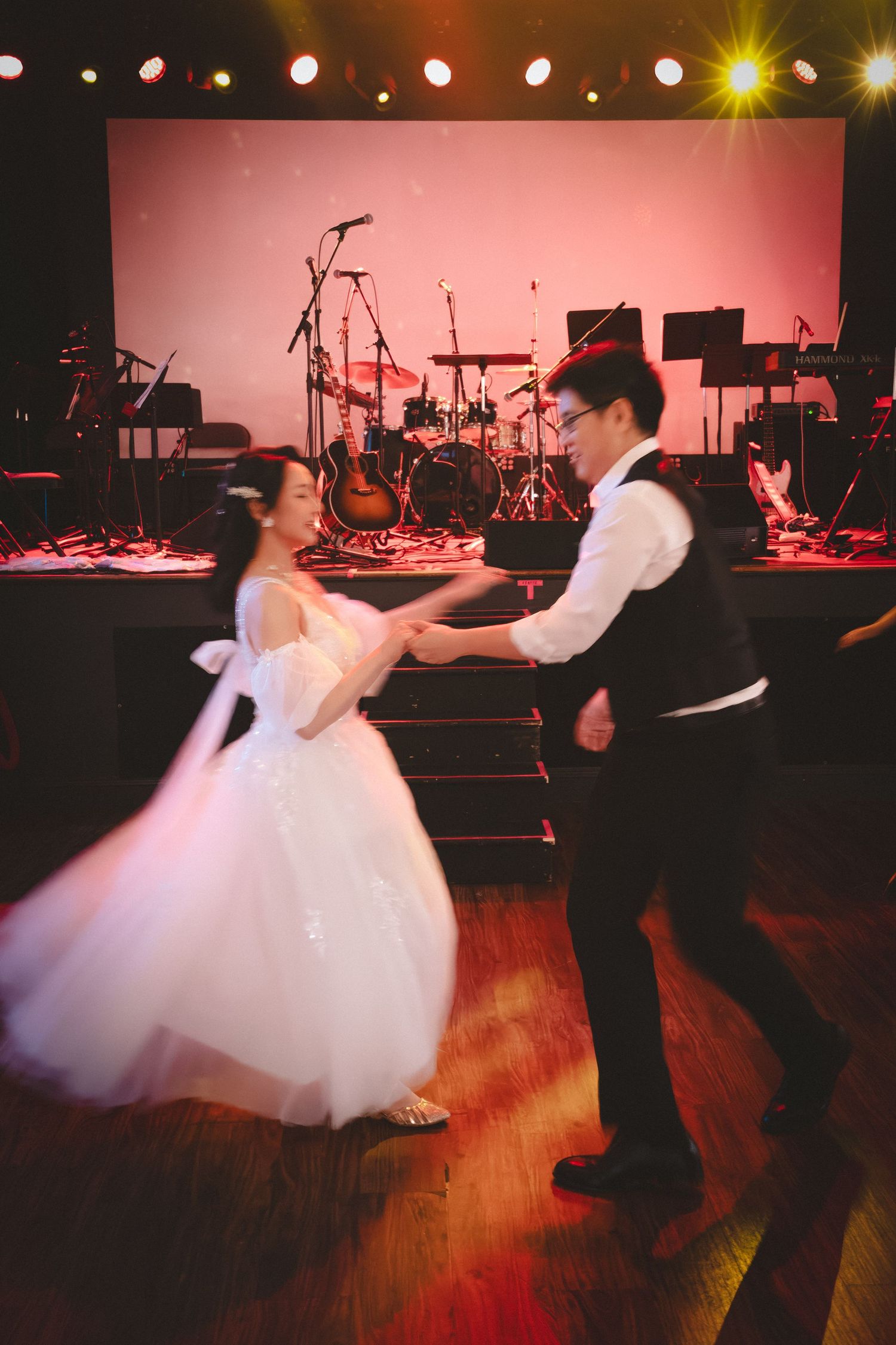 Bride and groom dancing during their wedding reception at an intimate indoor celebration.