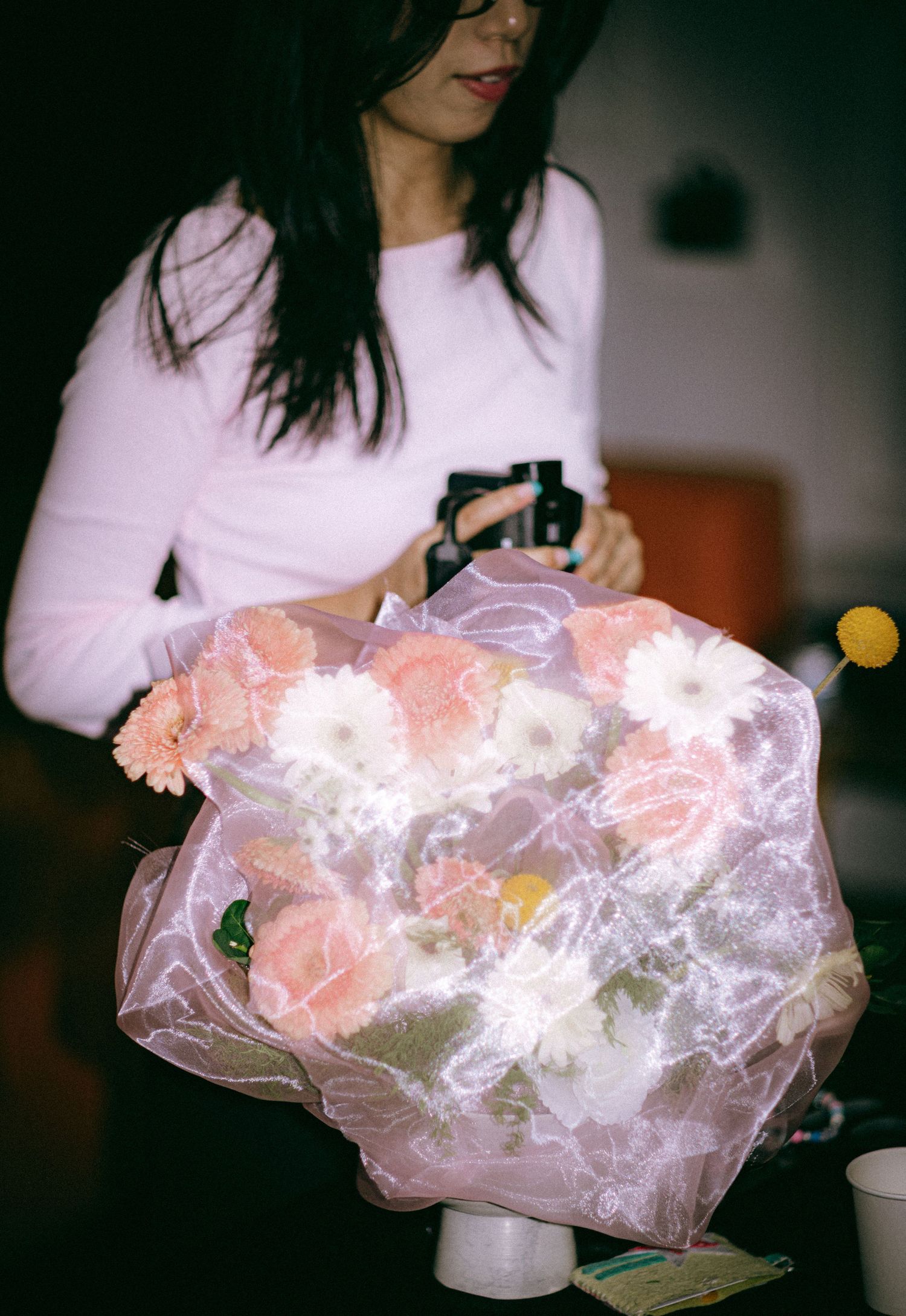 Floral arrangement with pink fabric over with a girl in pink standing behind