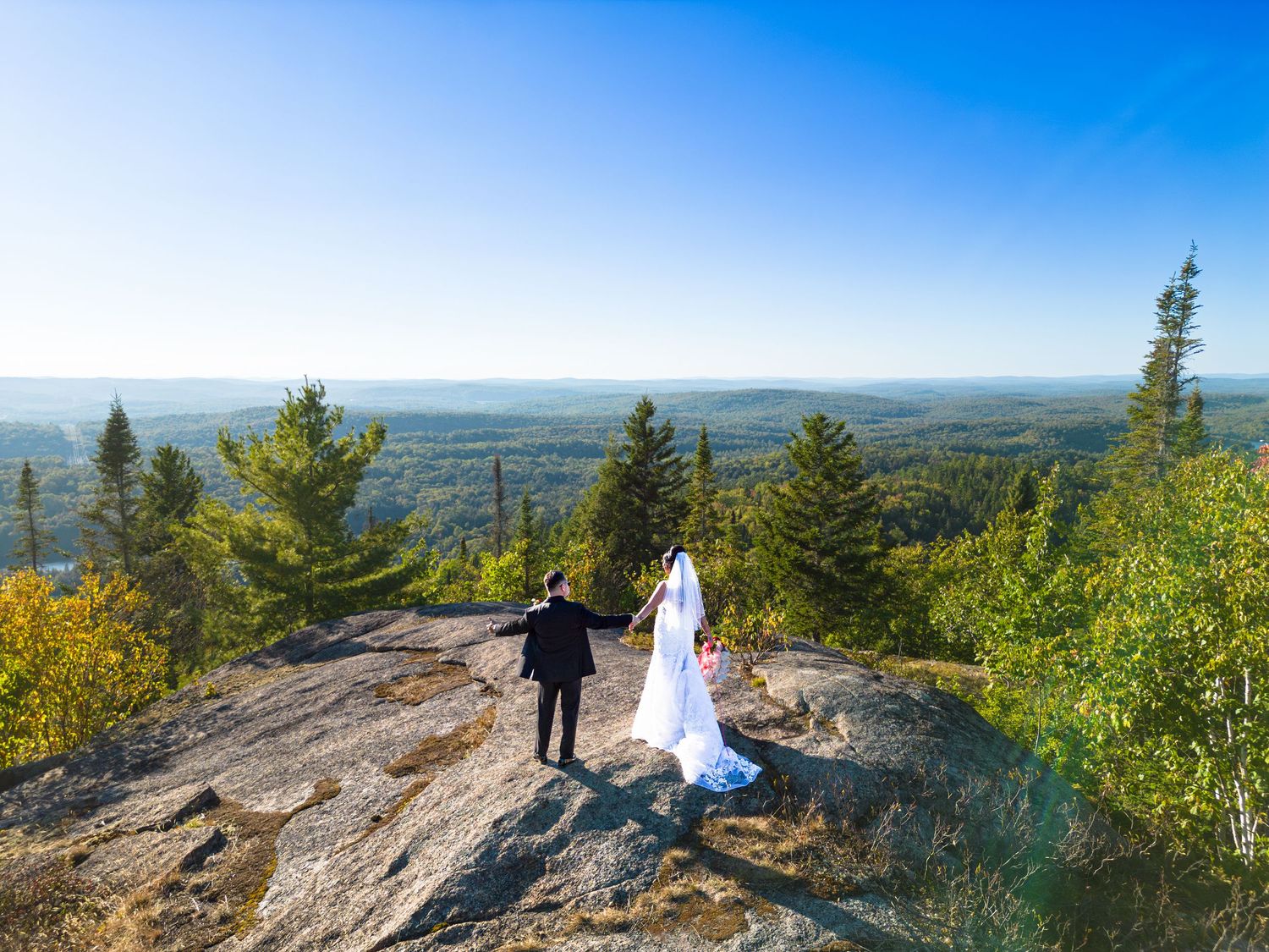 Wide landscape wedding photos captured on a mountain peak with expansive valley views.