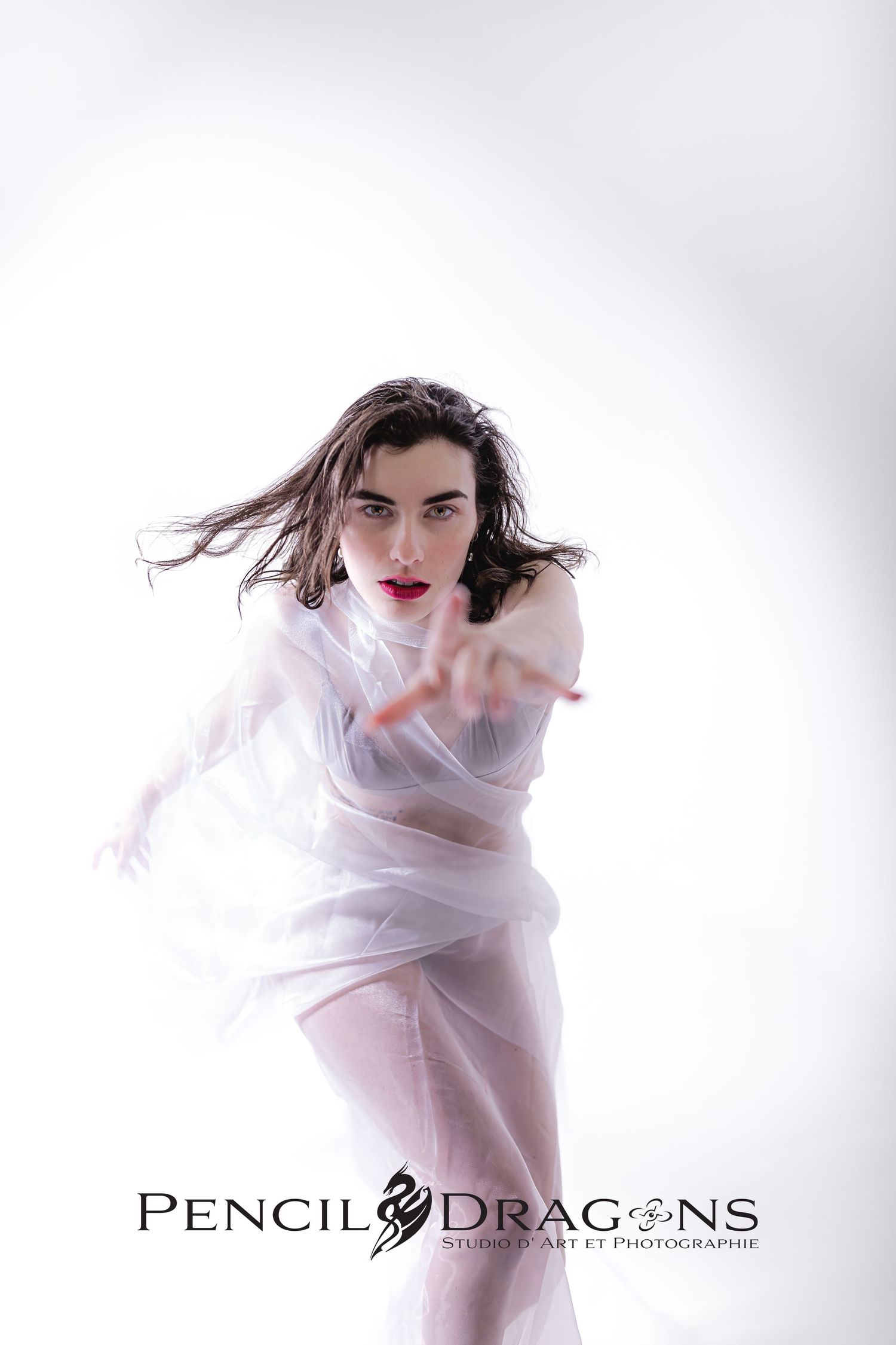 Ethereal portrait series featuring flowing white fabric and dramatic lighting.