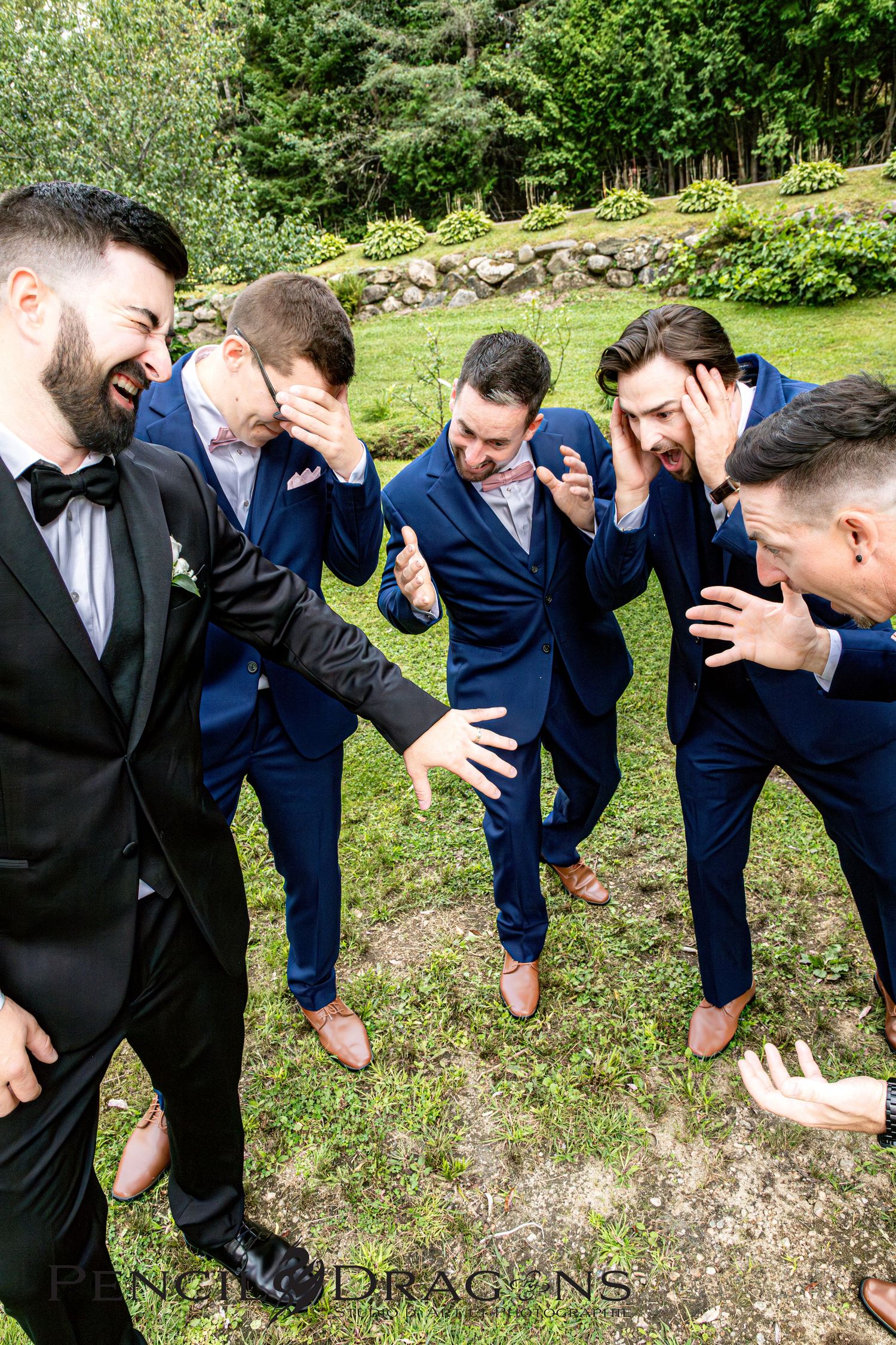 Wedding party members in blue suits perform synchronized bending poses on grass.