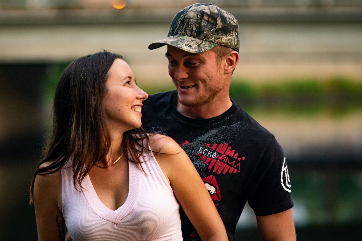 Couple in casual summer attire sharing intimate moments outdoors.