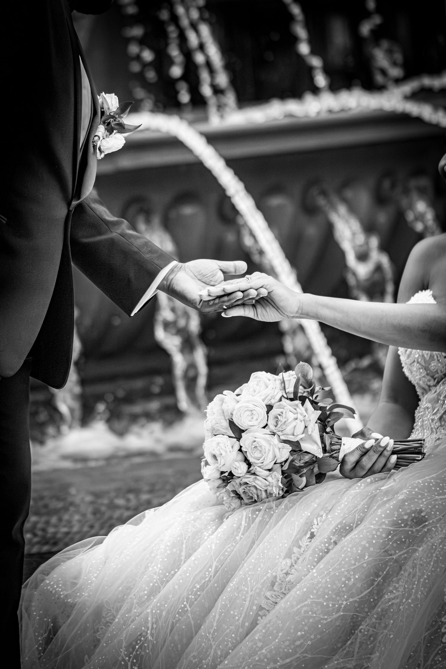 Black and white detail shot of wedding dress with delicate floral arrangements.