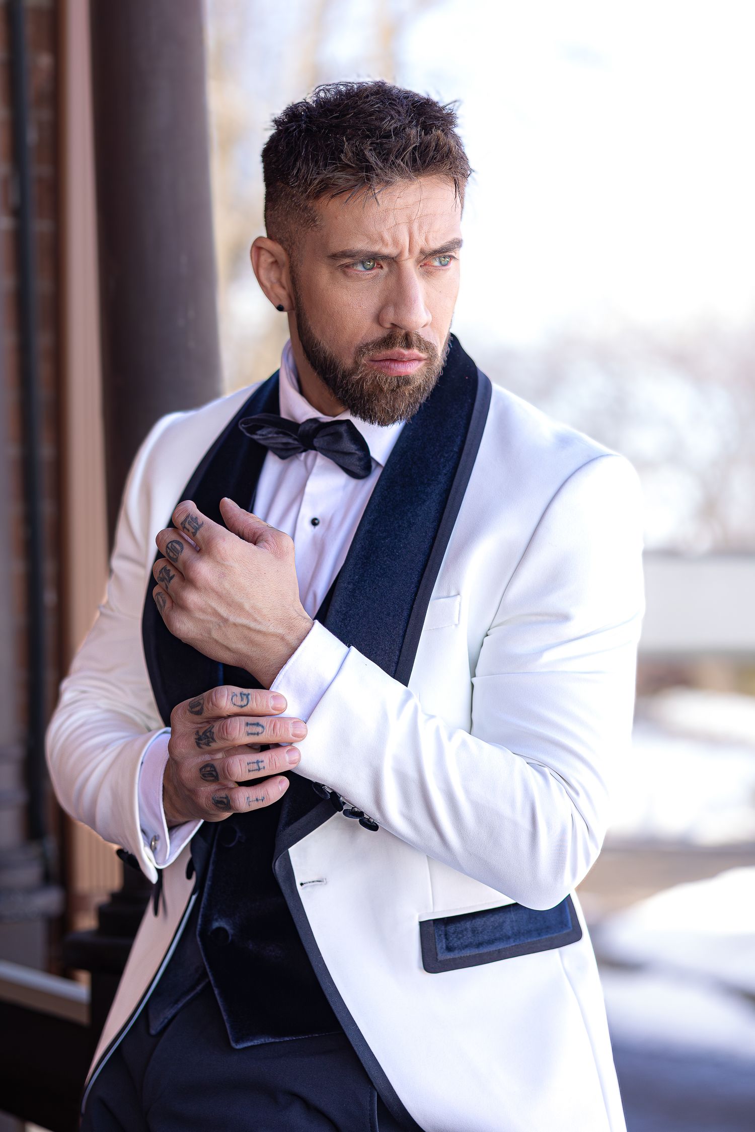 A person in a white blazer and navy vest adjusts their collar while posing in a series of connected photos.