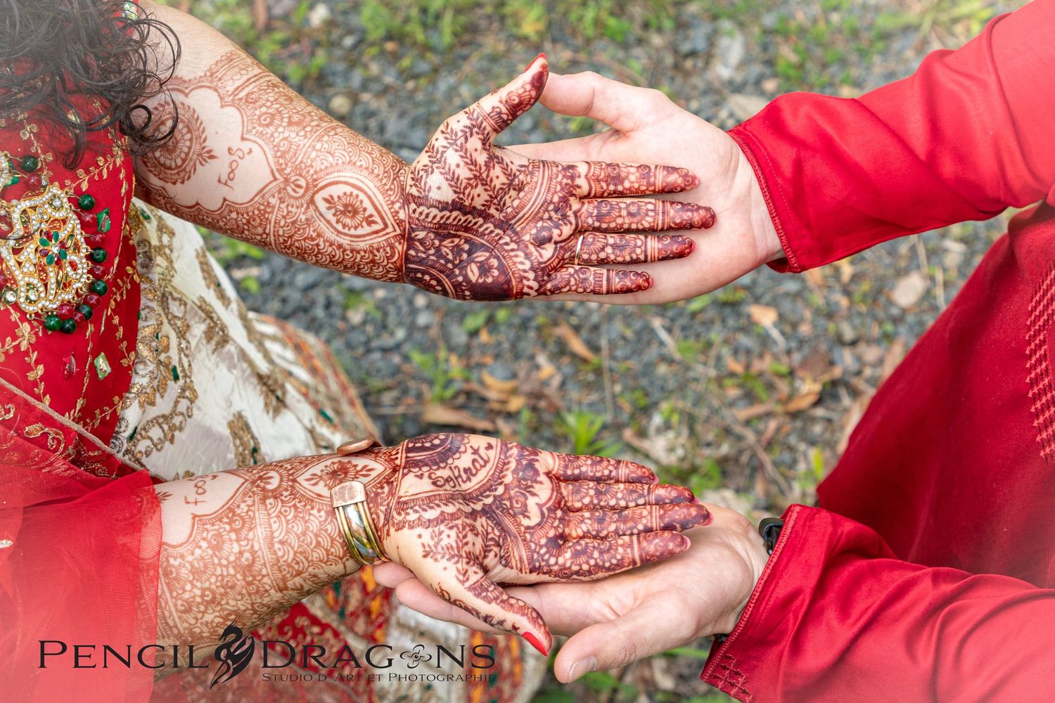 Detailed henna designs displayed on hands during a traditional wedding ceremony.
