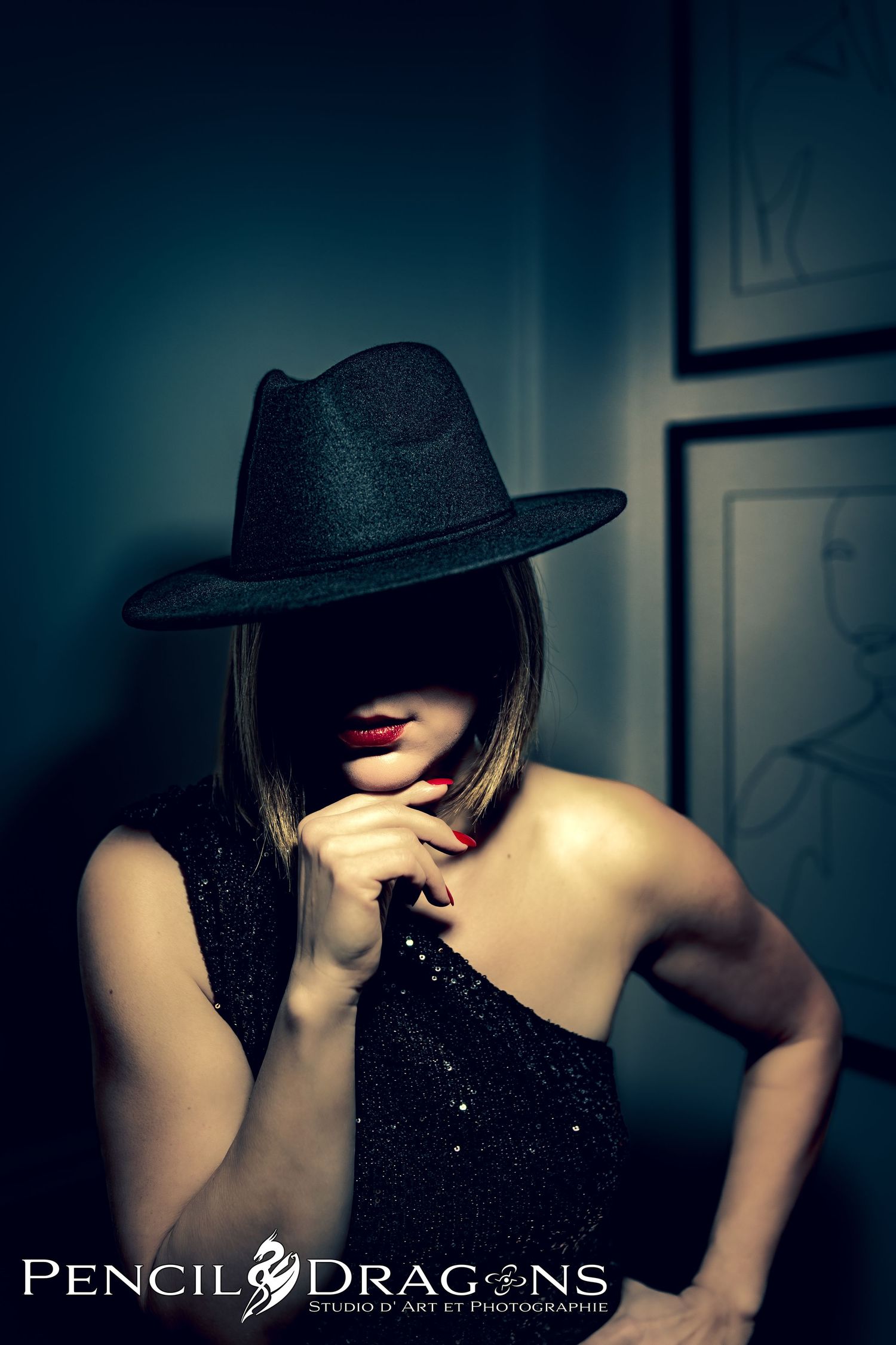 Dramatic boudoir series featuring black hat and sequined outfit in low-key lighting.