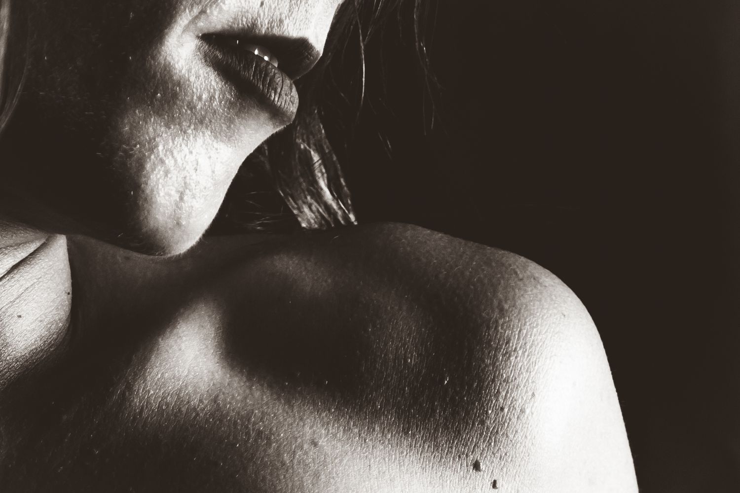 Artistic black and white close-up photography study of light and shadows on skin.