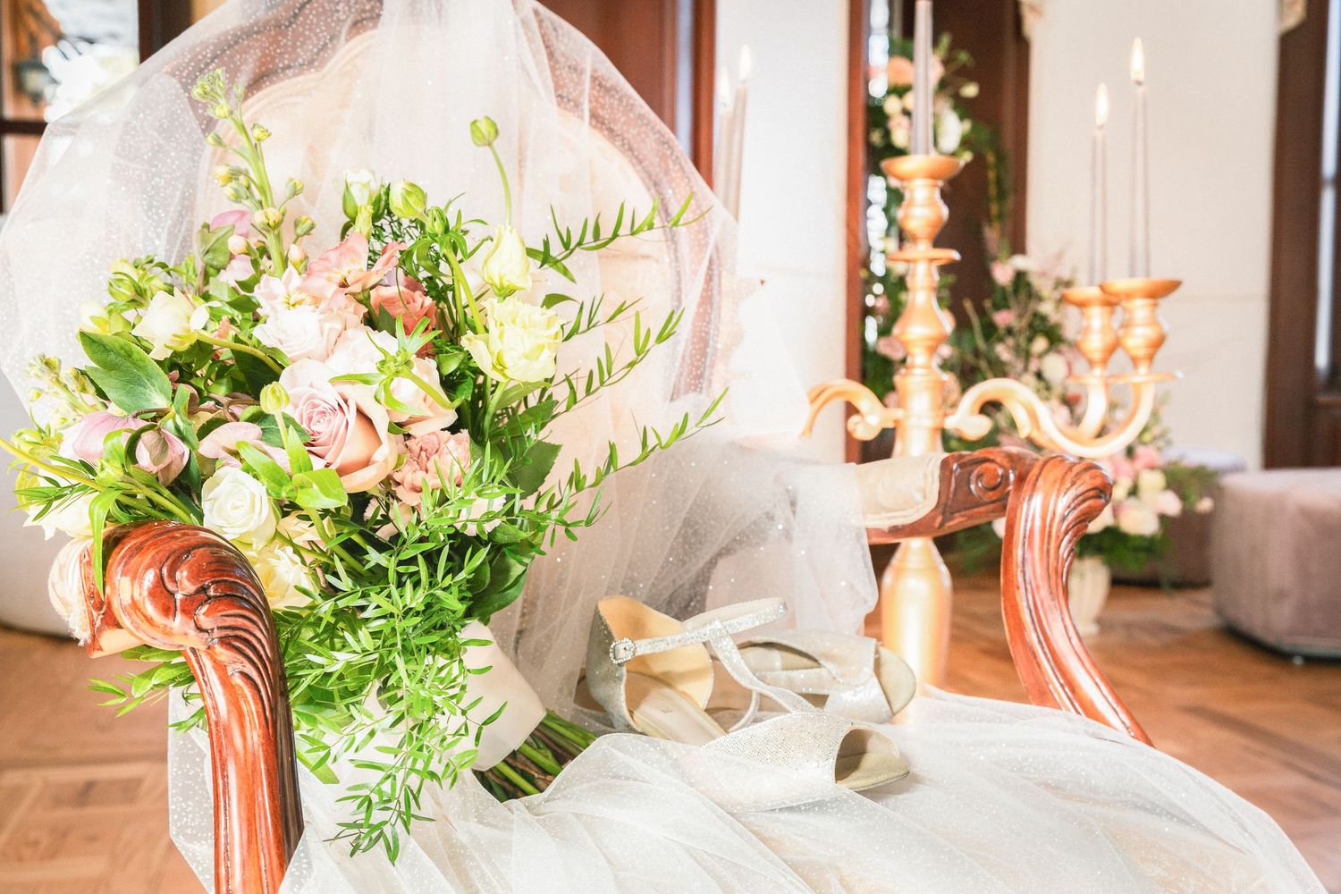 Elegant floral arrangements with pink and white flowers displayed in glass vases at an upscale event venue.