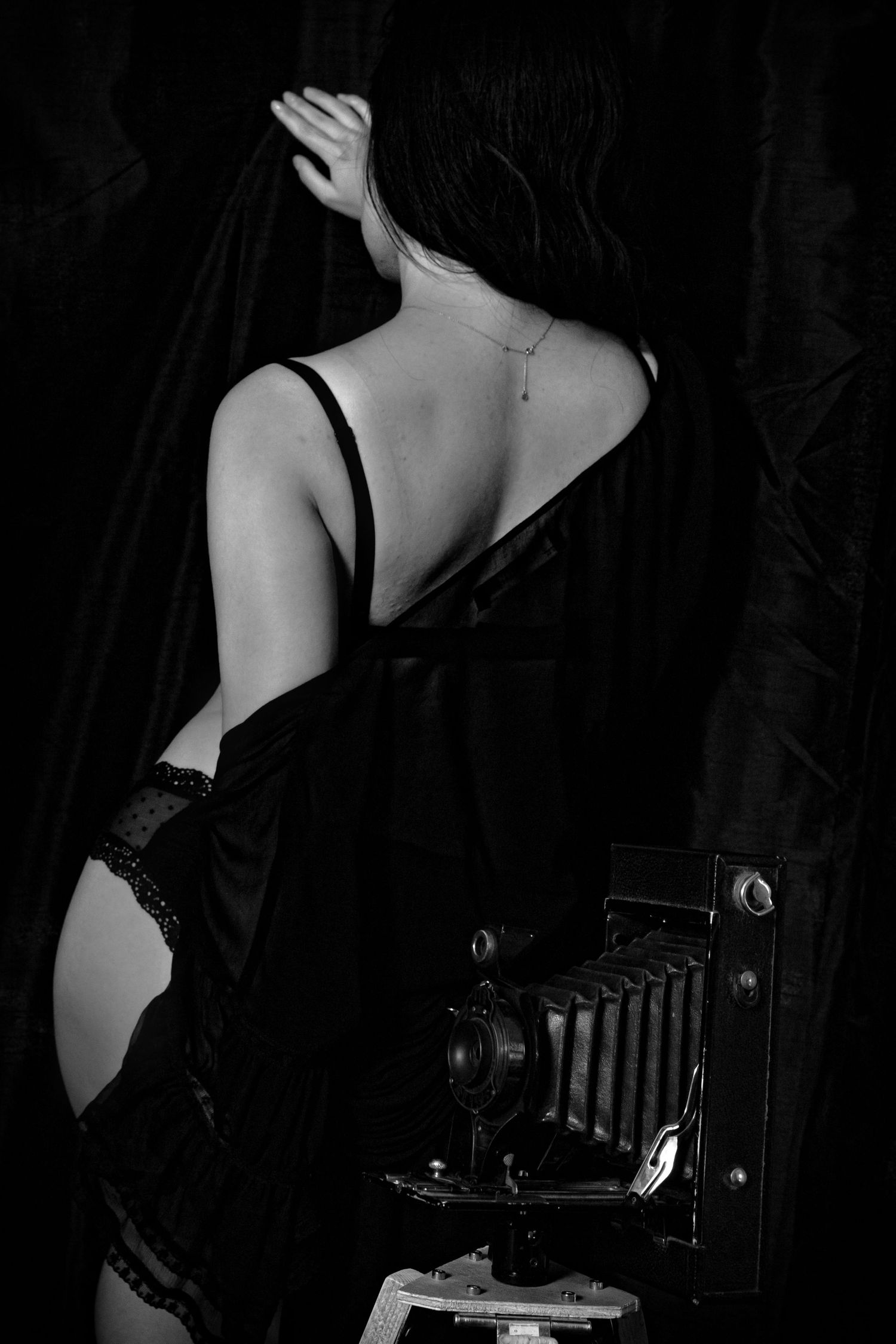Artistic black and white photo series featuring vintage camera equipment and feminine silhouettes.