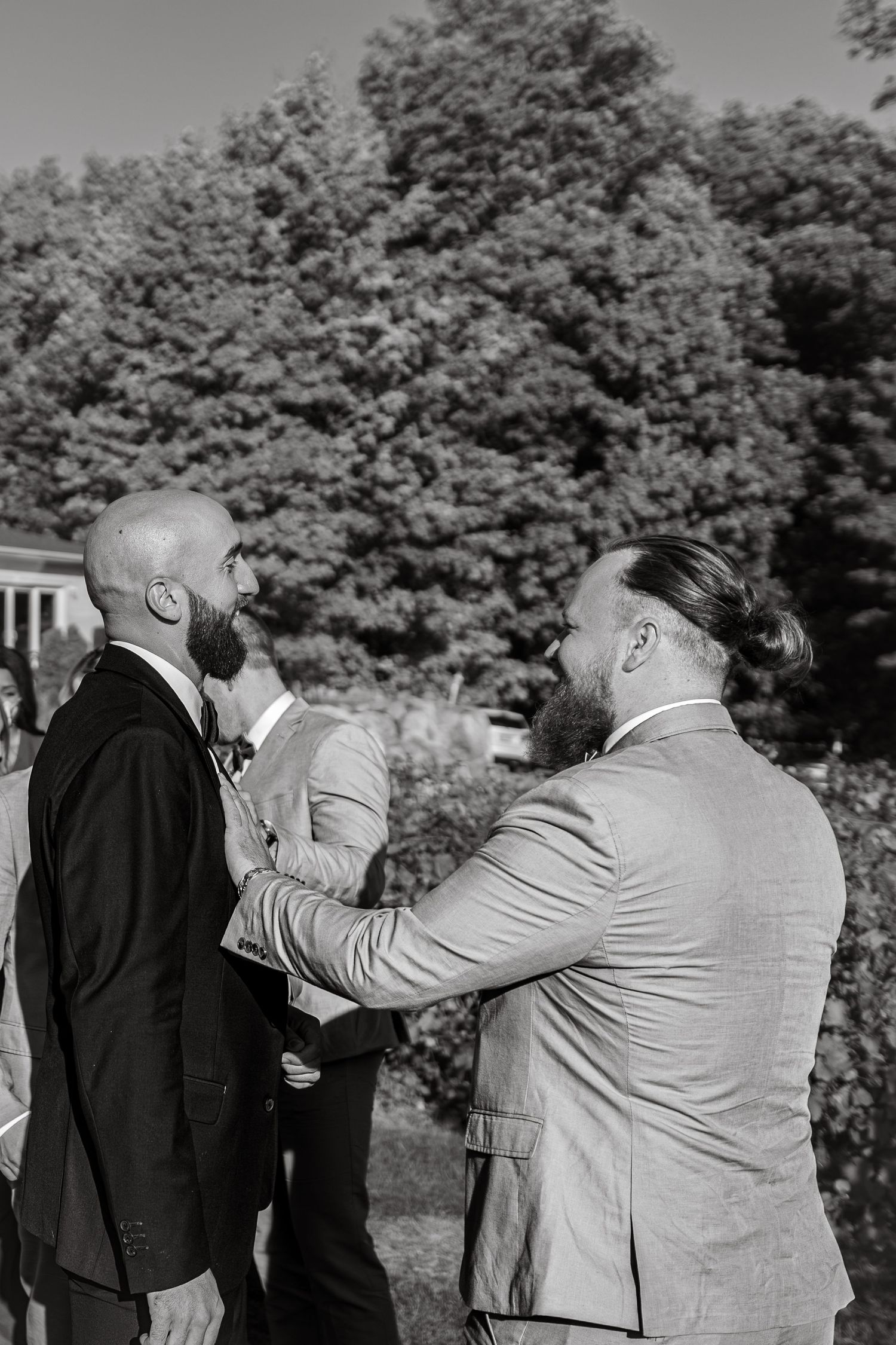 Black and white photo of formal event guests mingling outdoors.
