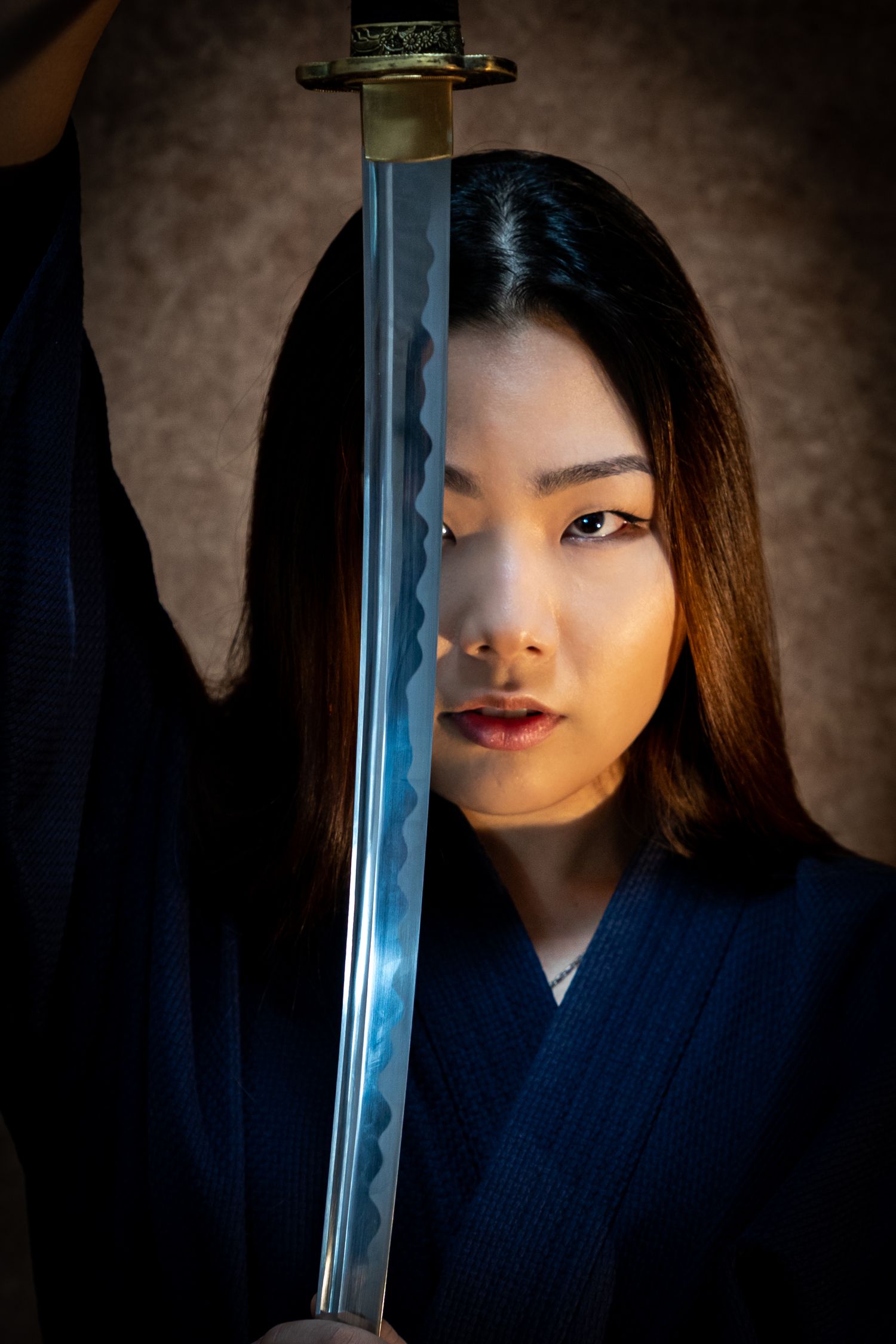 Dramatic portrait series with samurai sword and navy blue traditional garment.