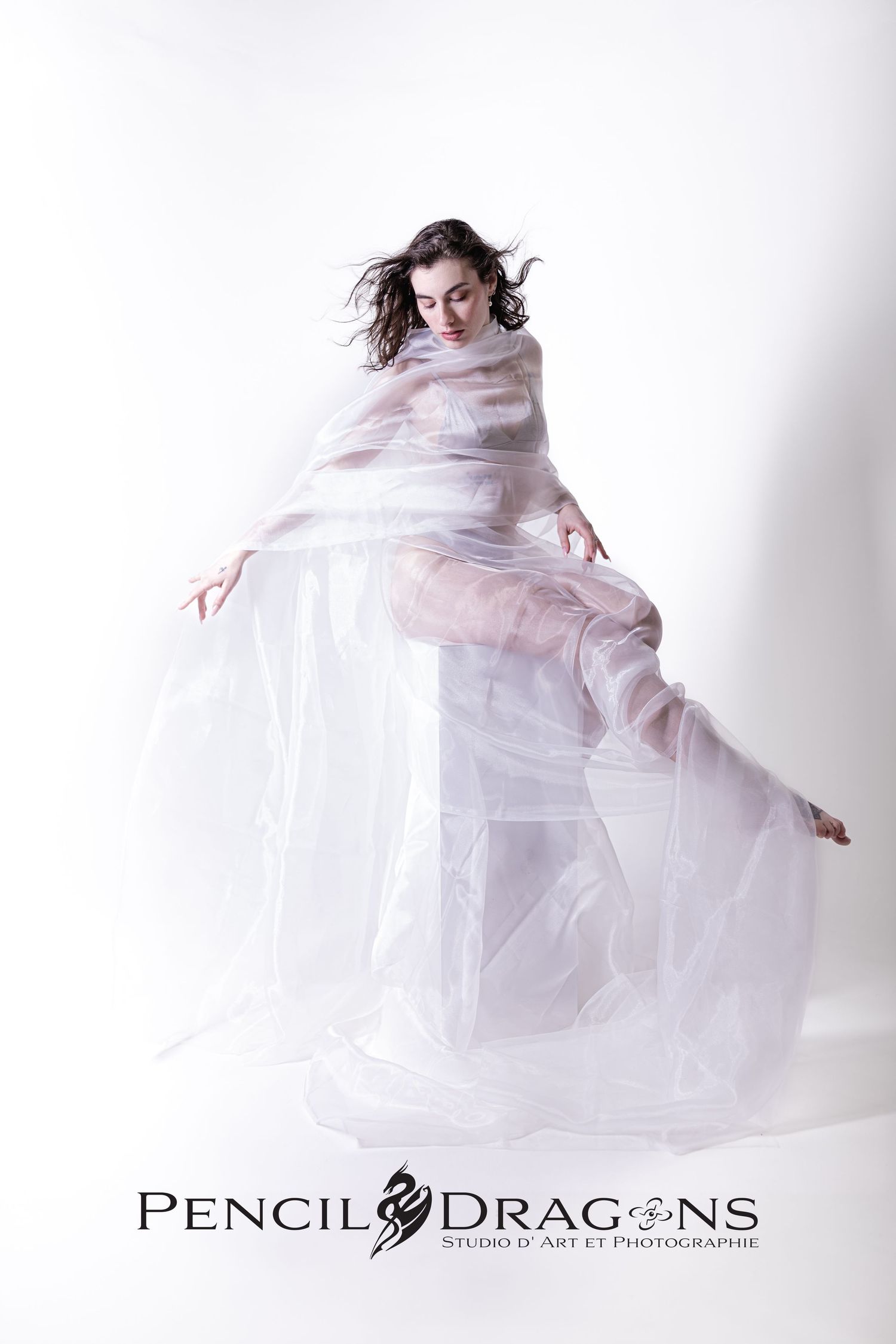 Dramatic sequence showing movement with billowing white sheer fabric in studio setting.