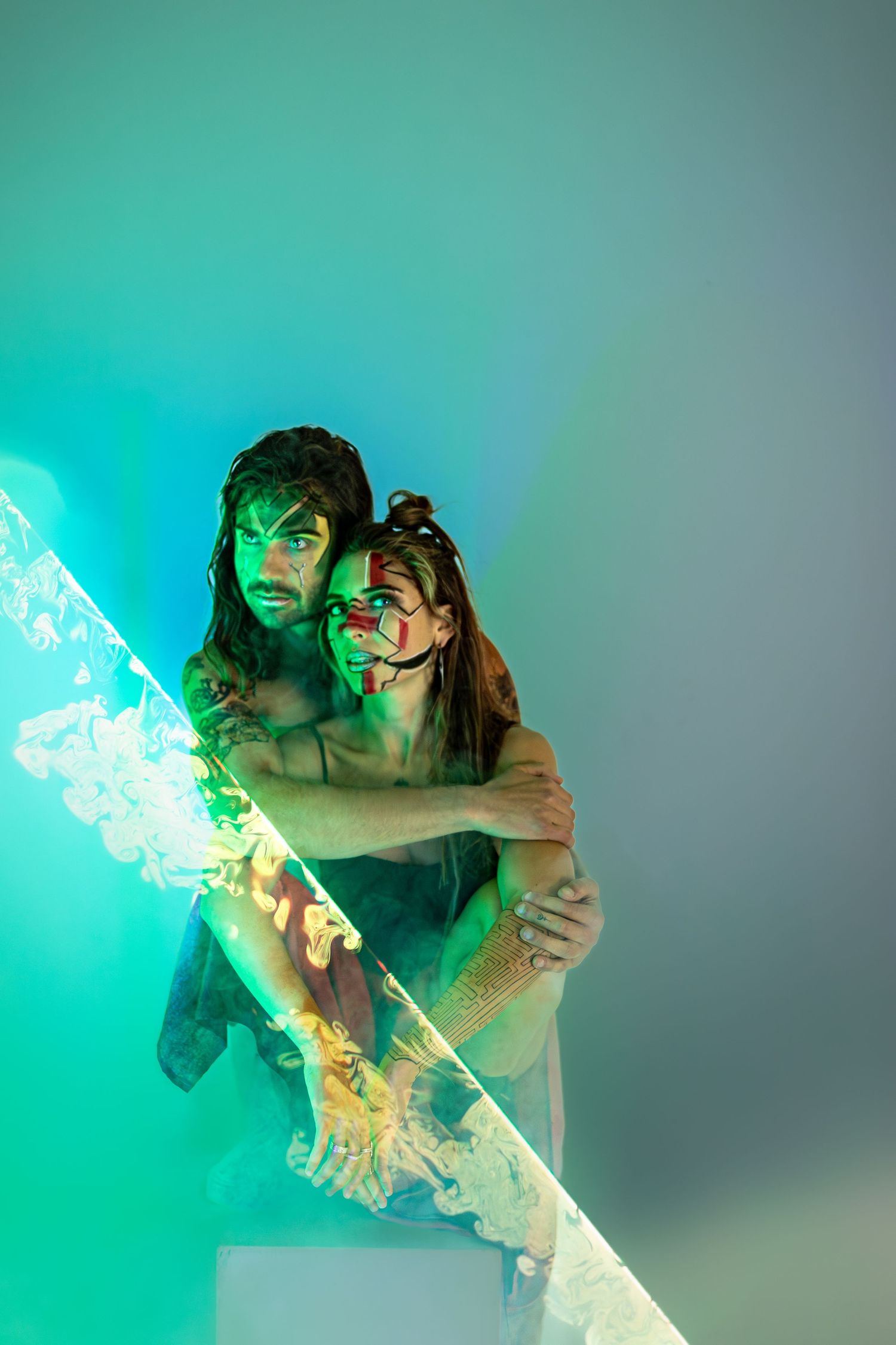 Artistic portrait with ethereal teal lighting and smoke effects.
