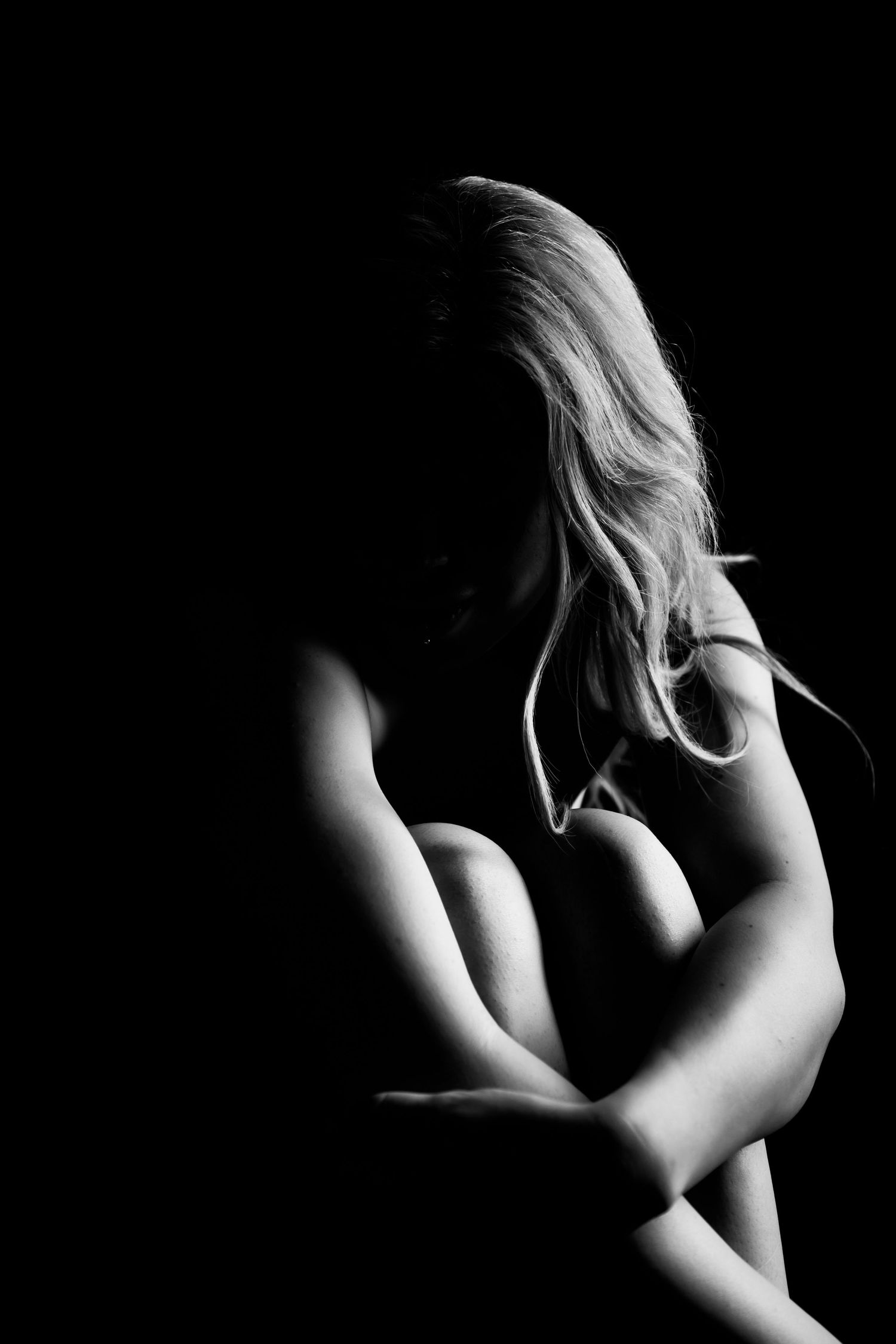 Artistic black and white nude photography study focusing on light and shadow.
