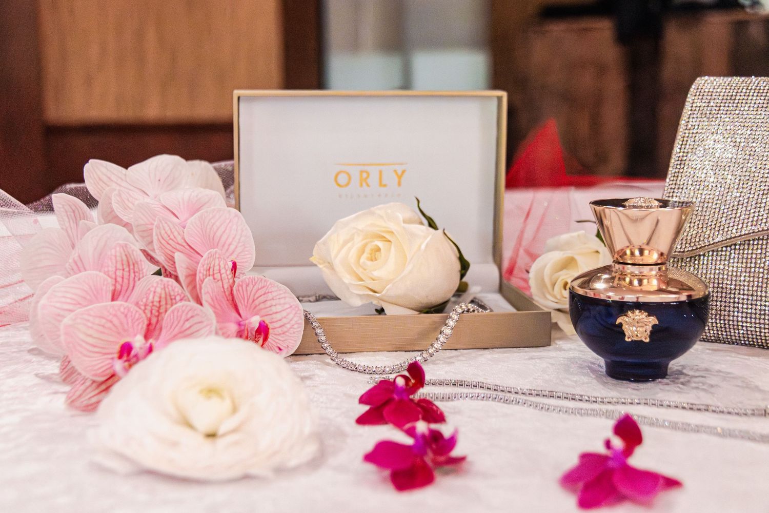 Elegant wedding reception table setting with pink flowers, gold accents, and decorative place settings.