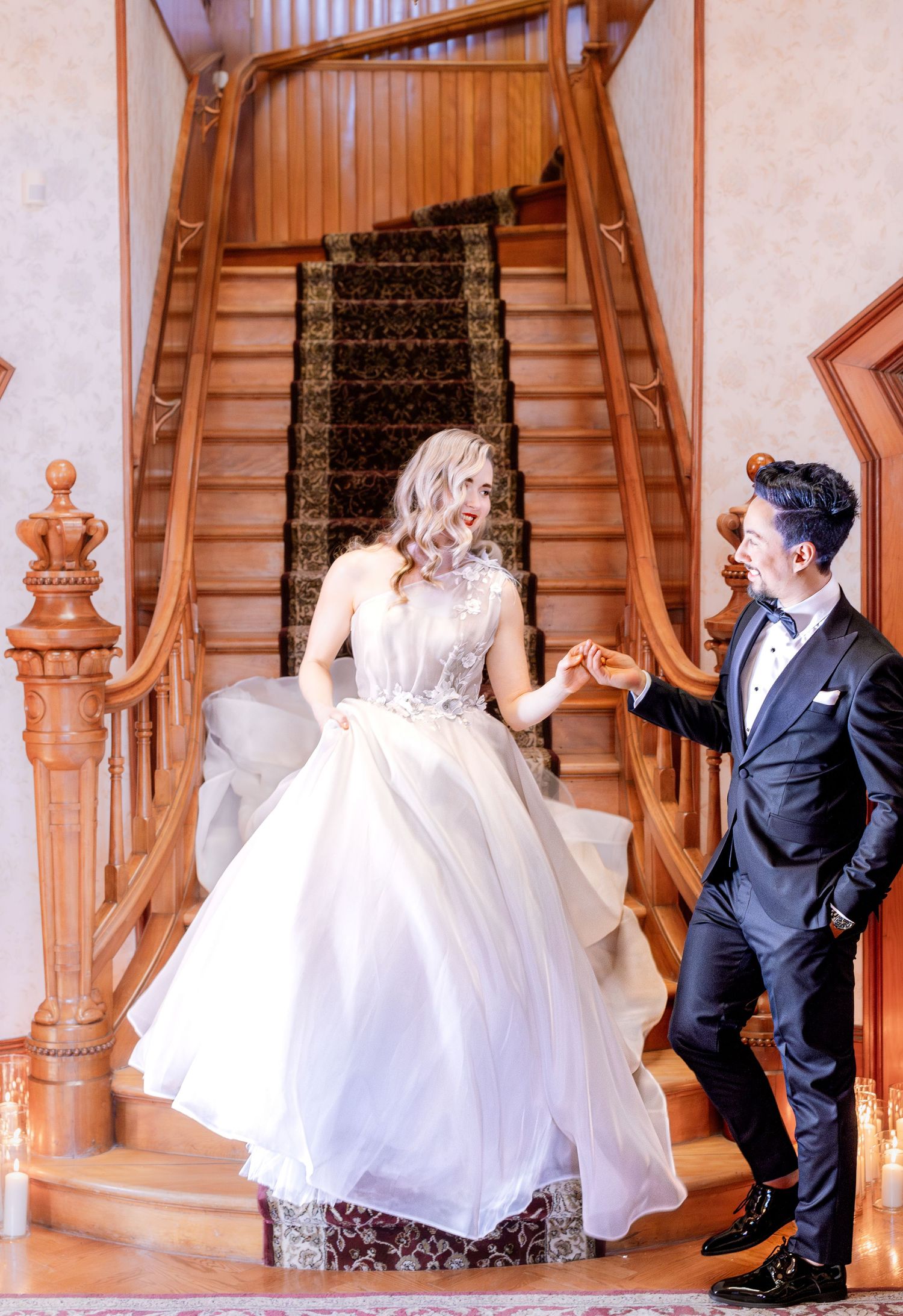 A couple poses playfully on wooden stairs in wedding attire during a photo sequence.