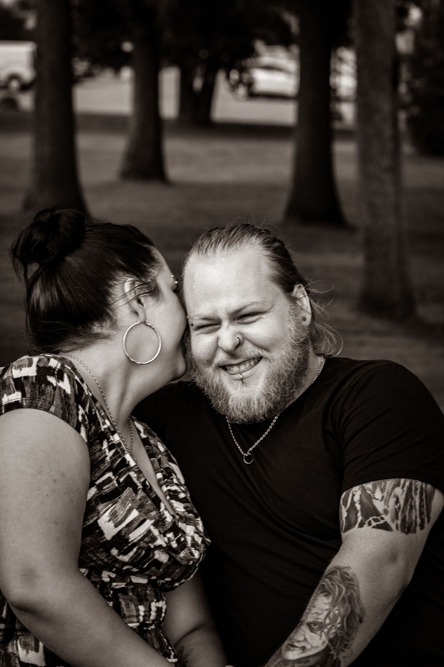 Intimate black and white portrait of couple sharing tender moment outdoors.