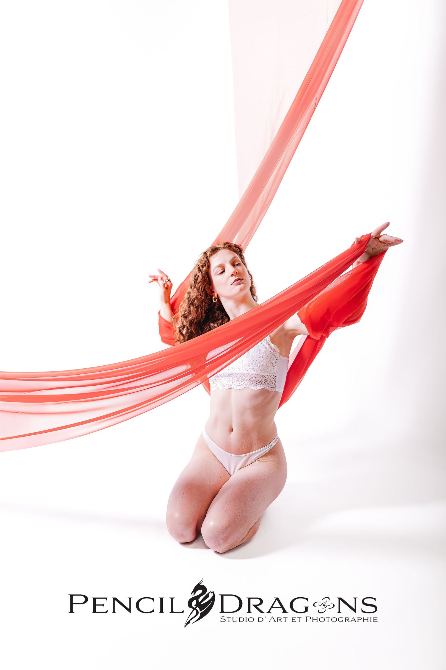Elegant portrait series with flowing red fabric and white lingerie against bright background.