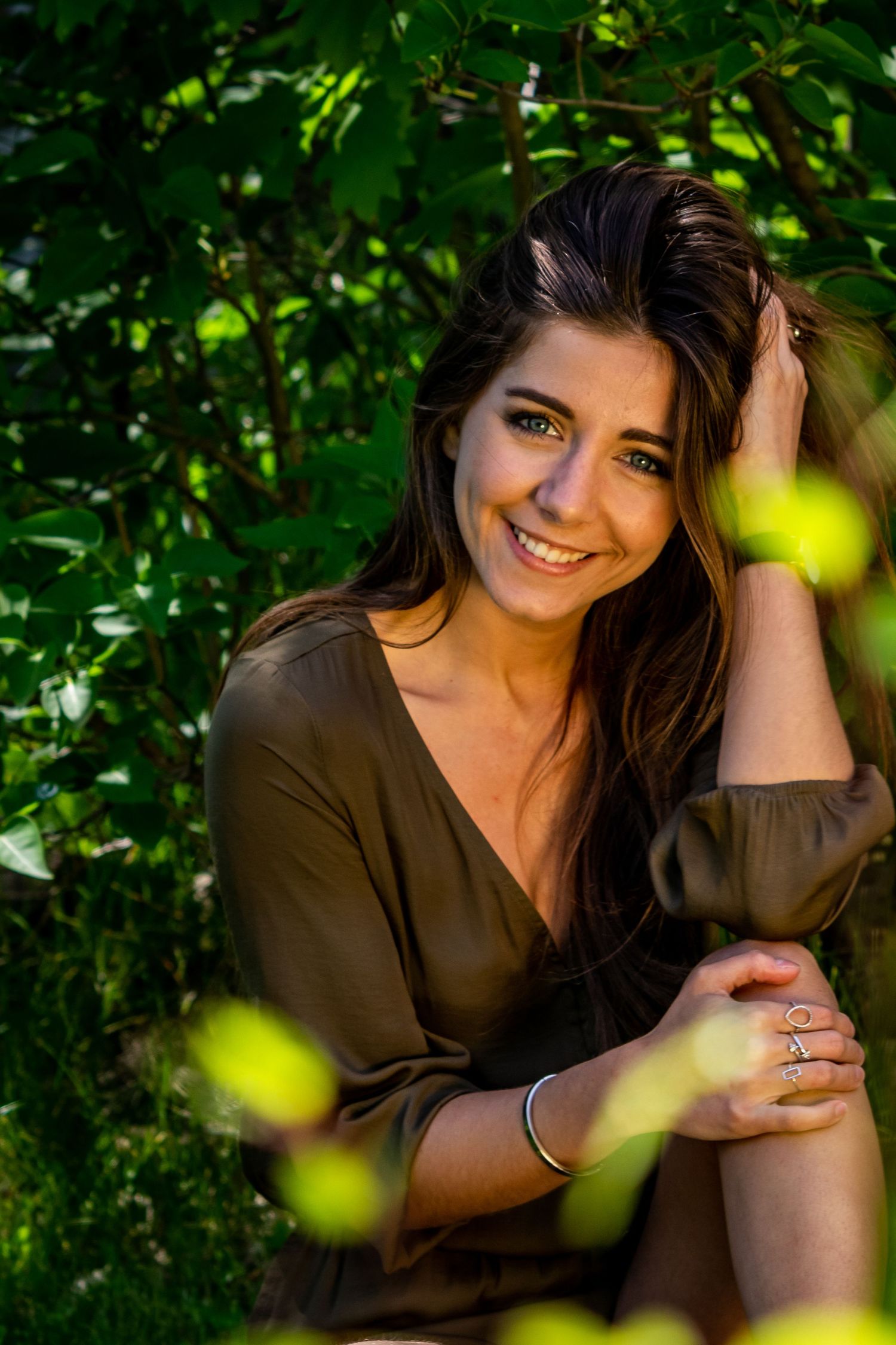 Portrait series in a lush garden setting with natural sunlight filtering through green foliage.