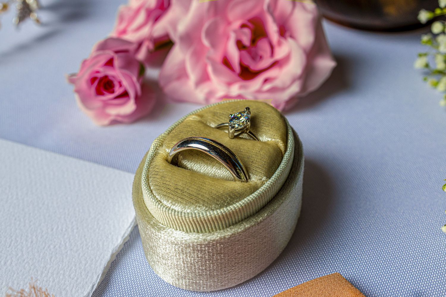 Pink roses and delicate gold ribbon create an elegant wedding or celebration decor arrangement on a light surface.