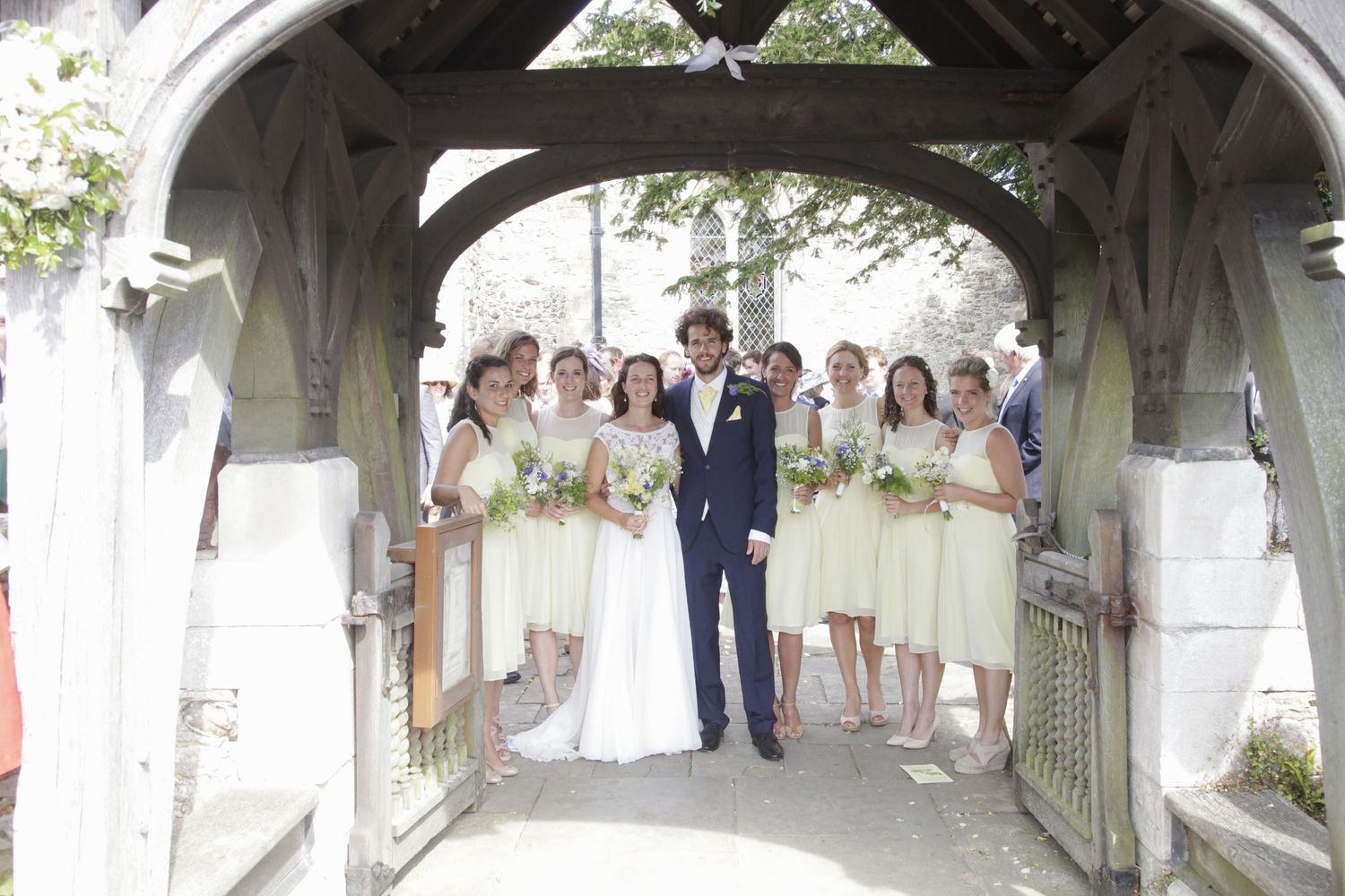 Stone church entrance archway decorated with white flowers for wedding ceremony.