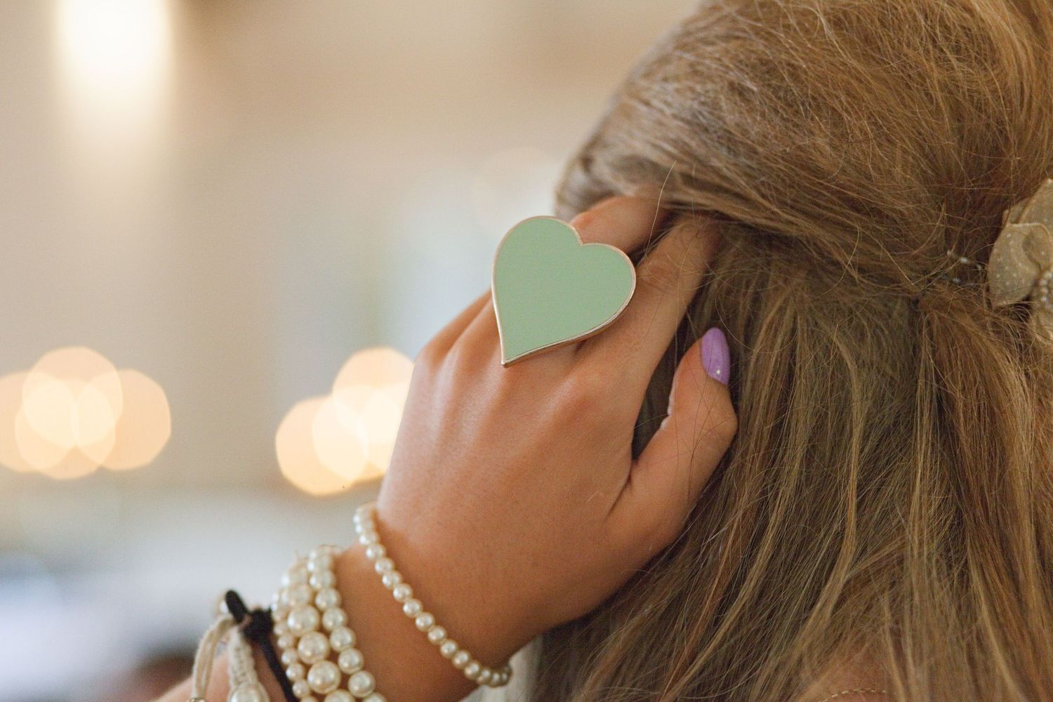 Close-up detail of mint green hair accessories and pearl jewelry.