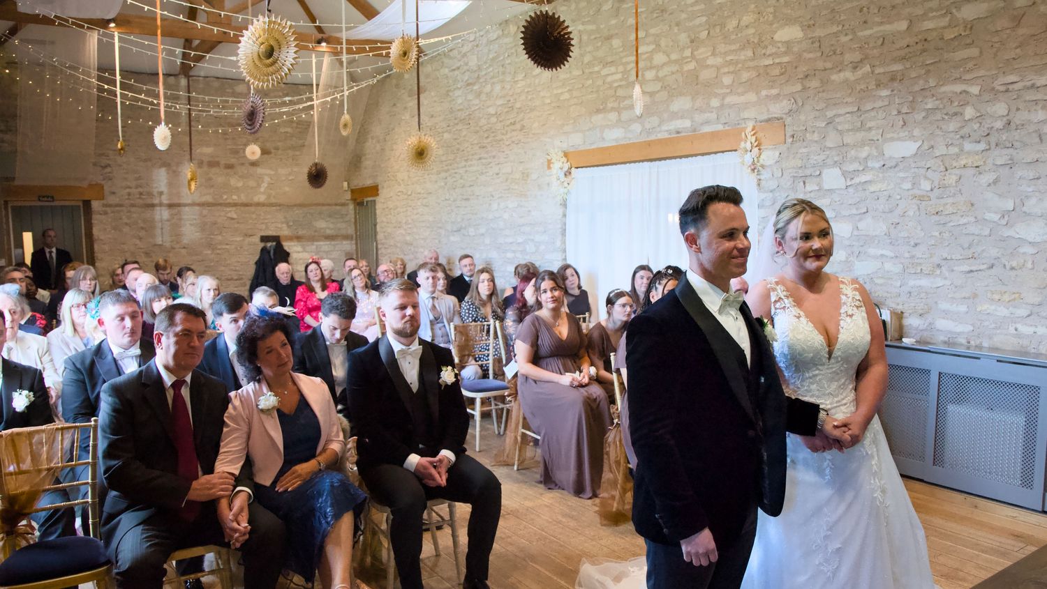 Wedding guests celebrating in an elegant venue with exposed brick walls and pendant lighting.