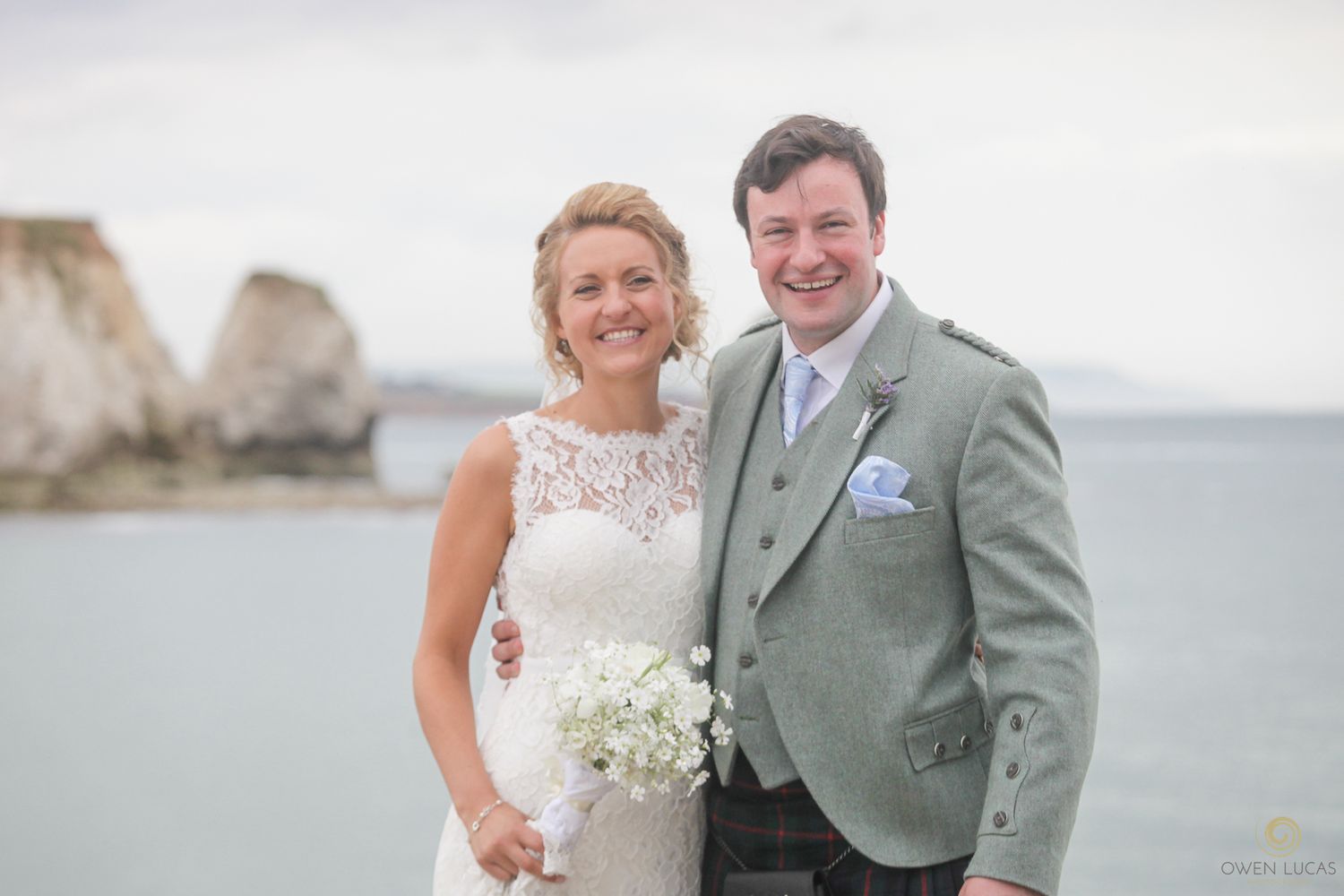 Romantic coastal wedding photography with white cliffs visible in the distance.