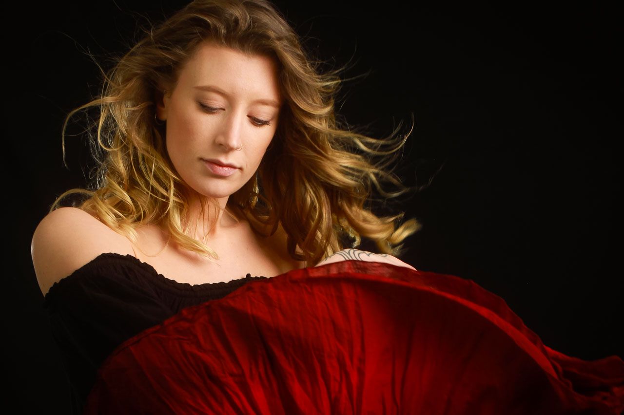Artistic portraits with flowing hair movement against dark background.