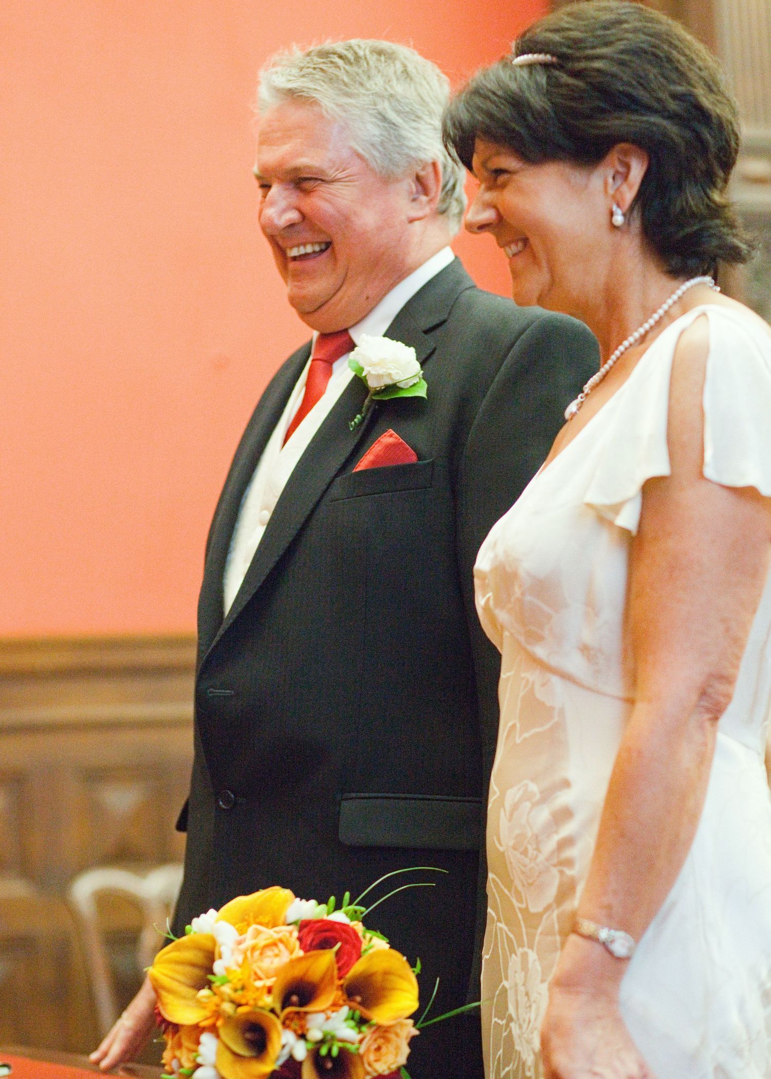 A couple walks together during a wedding ceremony, with sunflower bouquet details.