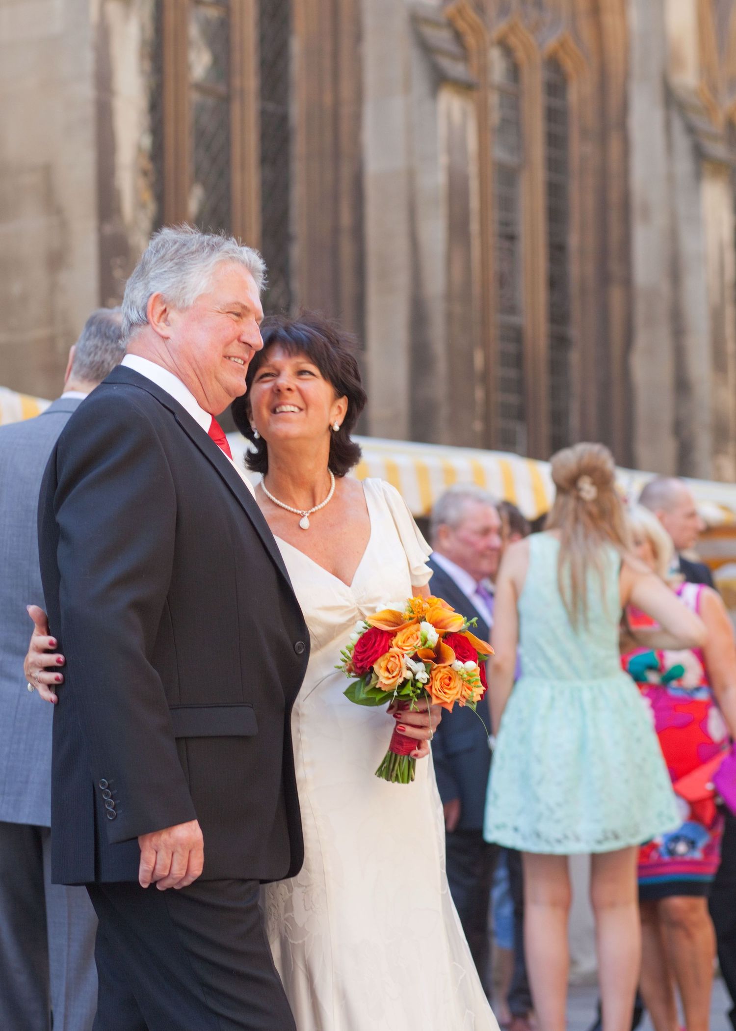 A couple shares a tender moment outside a church during their wedding celebration.