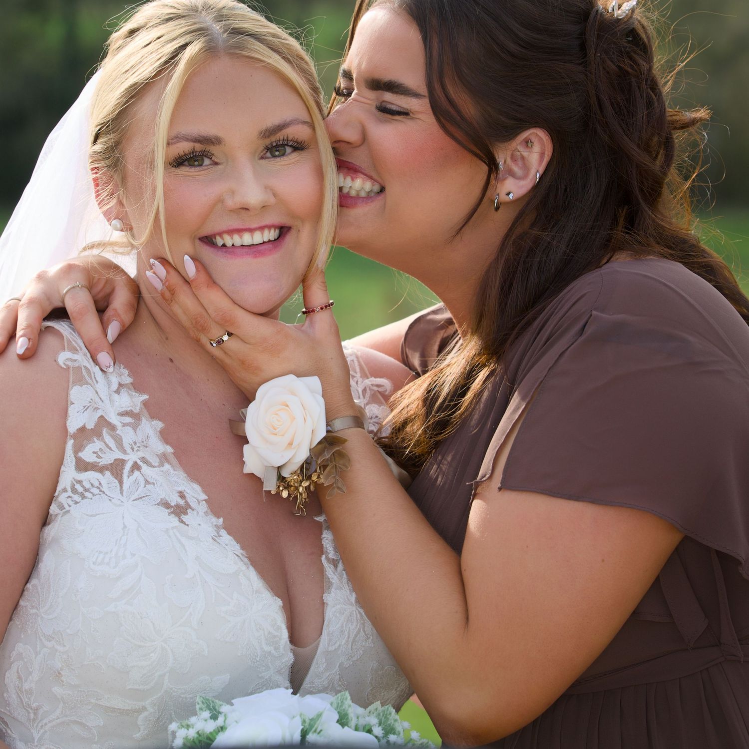 Bride and an excited bridesmaid hug during their wedding photography photo shoot in