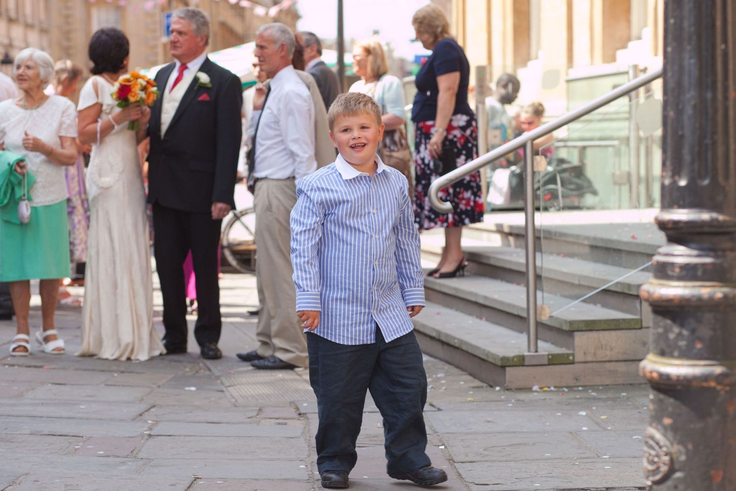 Wedding guests mingle and socialize on a historic stone-paved street.