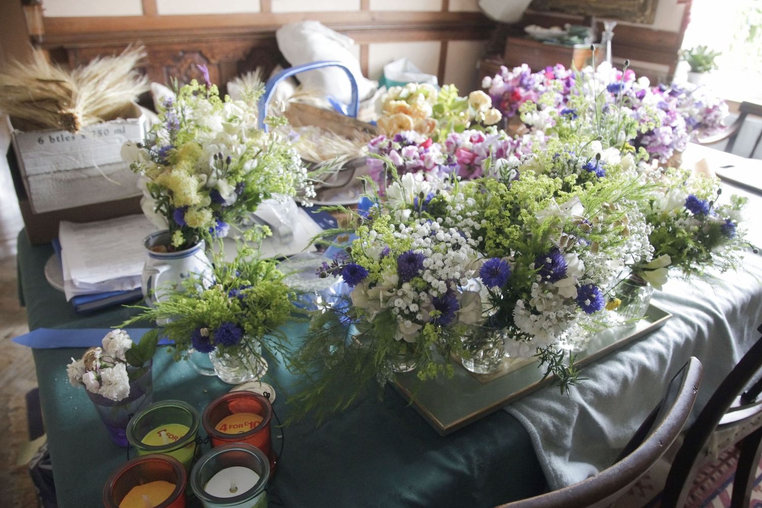 Long dining tables decorated with wildflower centerpieces and white tablecloths.