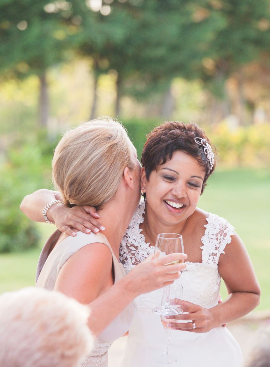 Candid reception moment showing guests sharing laughter at outdoor celebration.