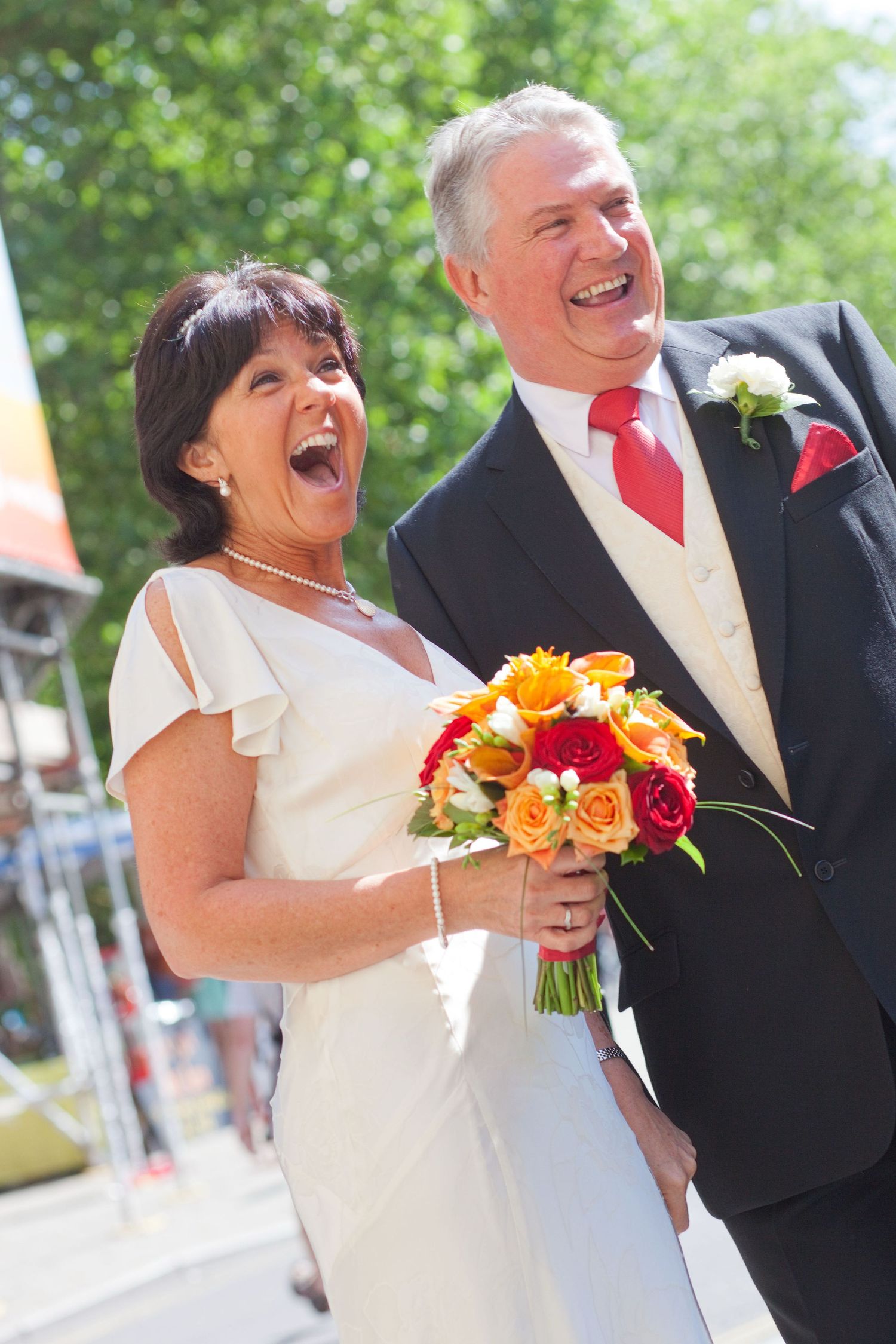 Series of candid wedding shots capturing laughter and joy between couple with orange and red bouquet.