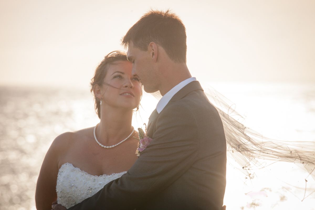 Romantic sunset portrait of newlyweds sharing an intimate moment.