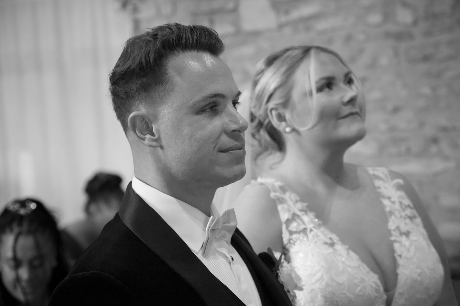 Intimate wedding ceremony moments captured in black and white at an indoor venue.
