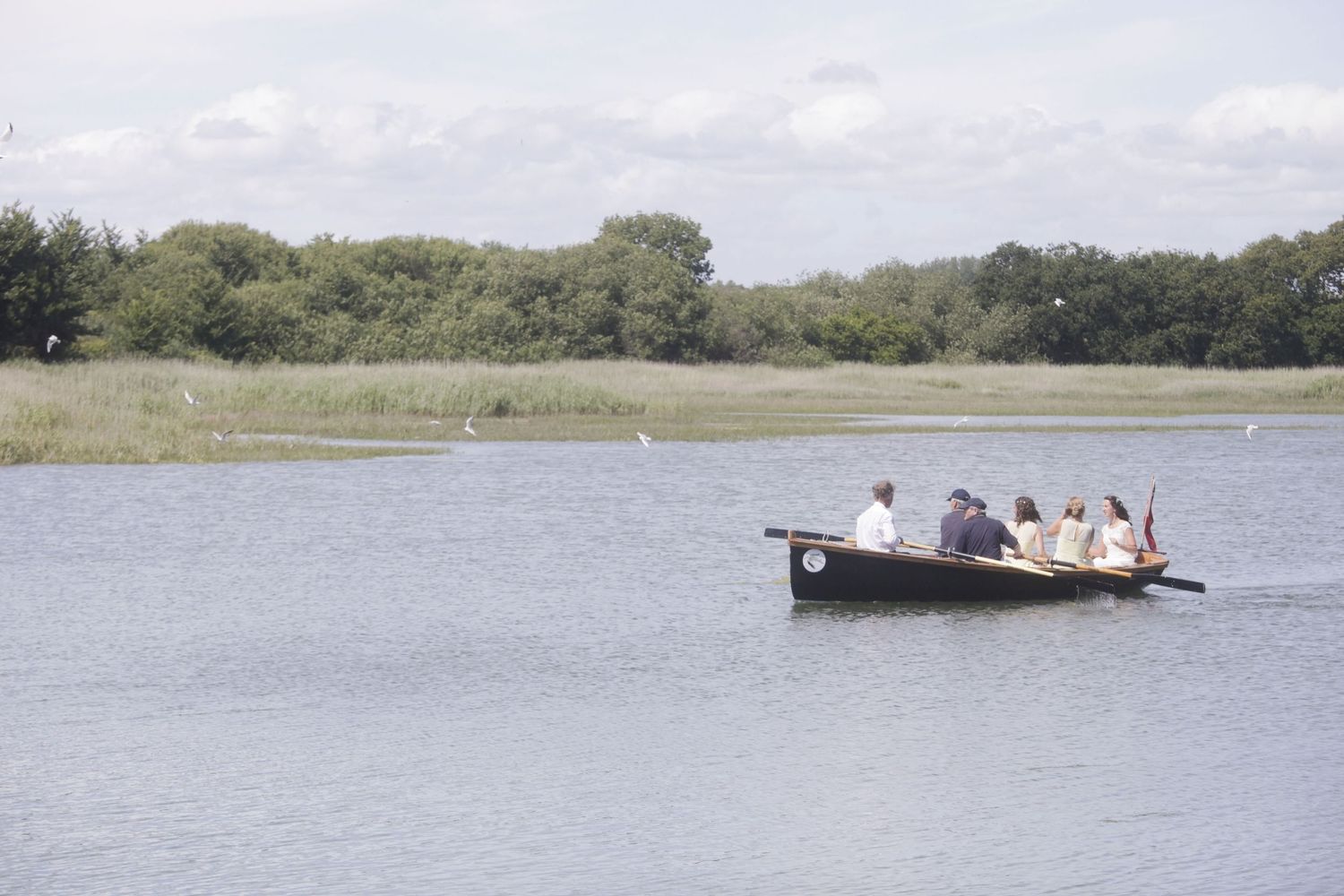 Small boat cruising on a calm lake surrounded by natural landscape.